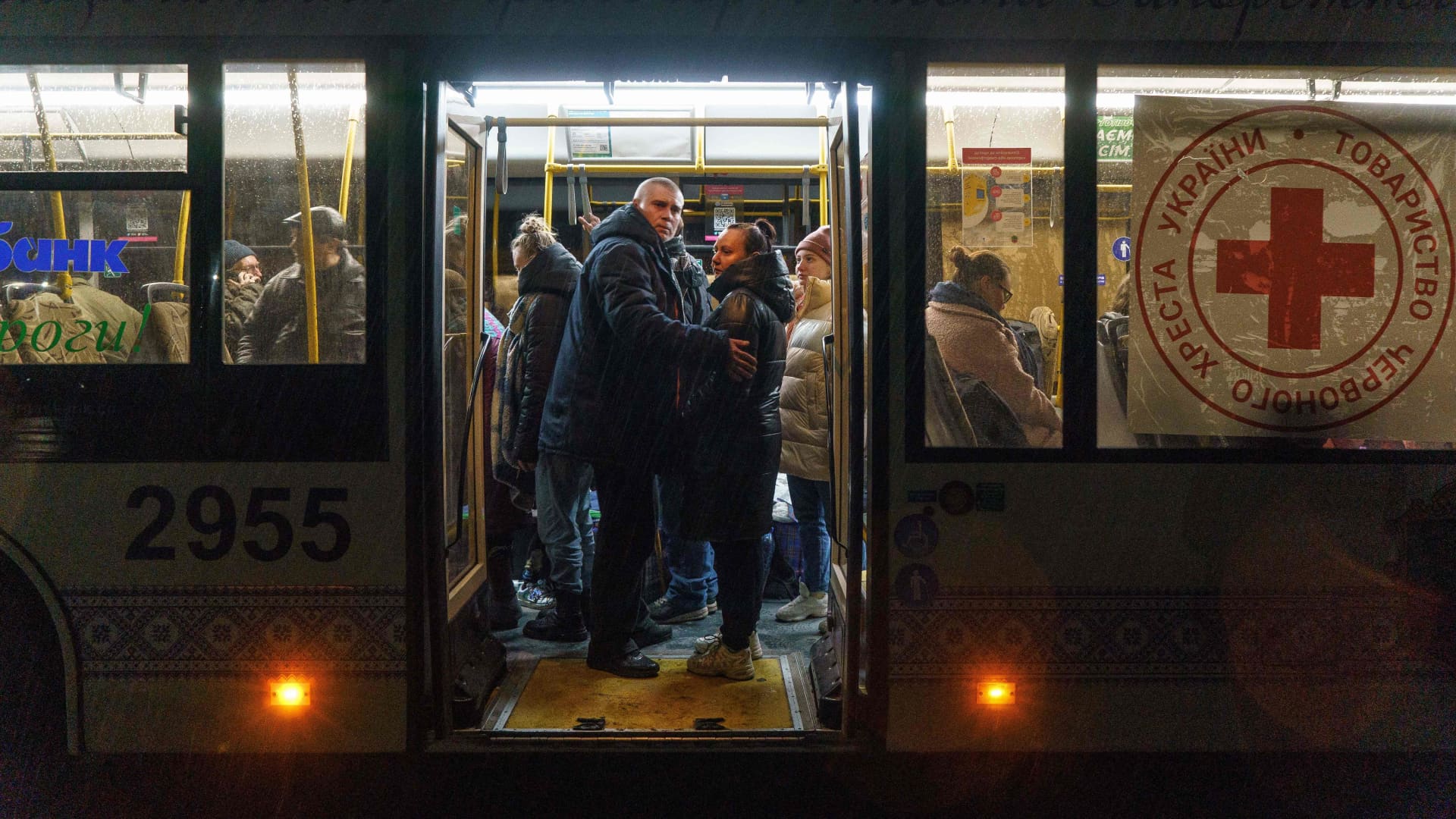 People stand in a bus as an evacuation convoy of buses and cars arrives at a displaced persons' hub in Zaporizhzhia, in the early hours of April 4, 2022.