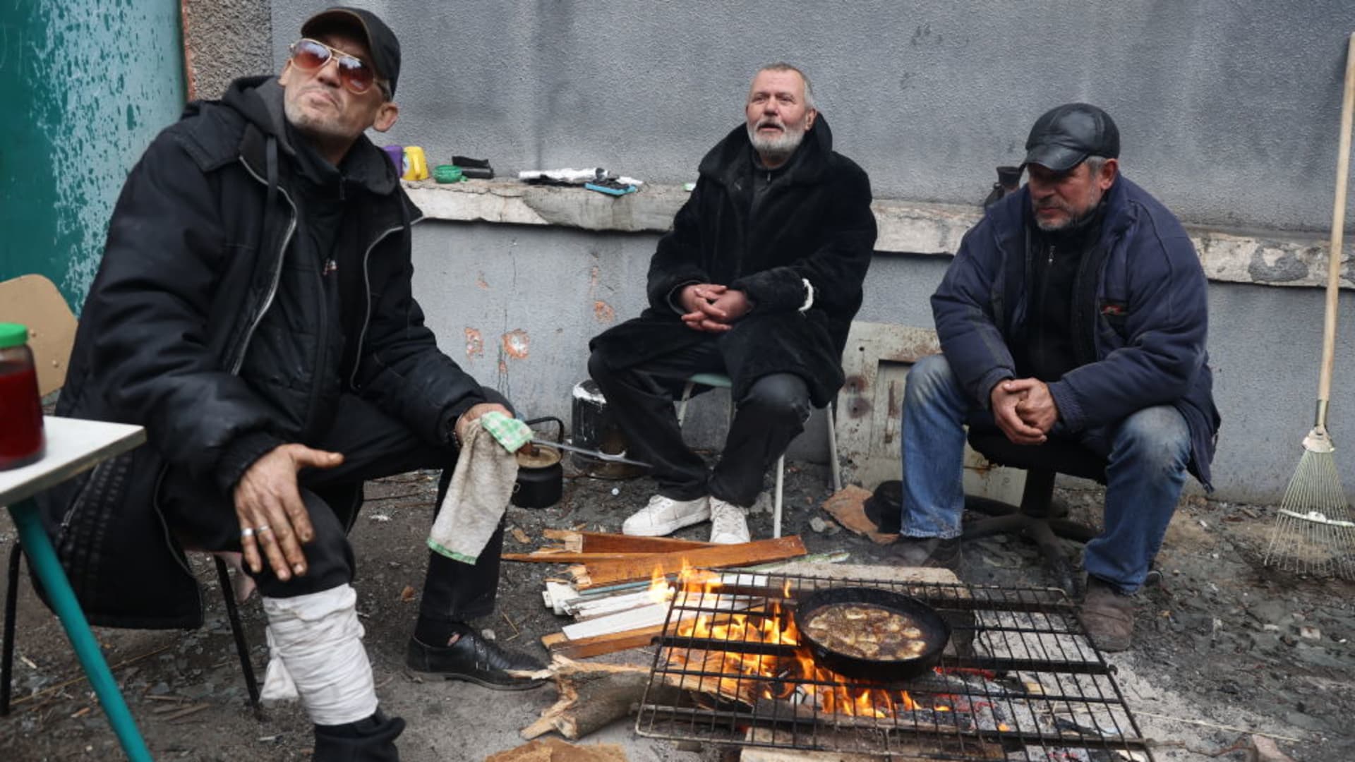 People cook a meal in Ukraine's besieged port city of Mariupol on April 4, 2022.