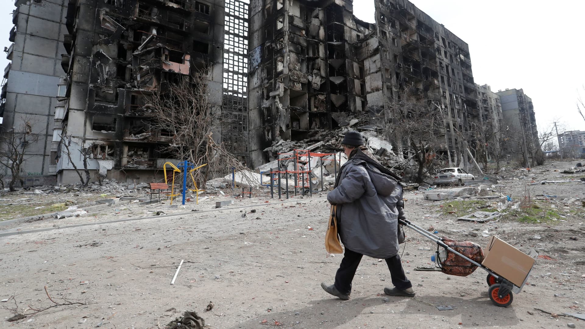 A local resident walks near an apartment building destroyed during Ukraine-Russia conflict in the southern port city of Mariupol, Ukraine April 3, 2022. 