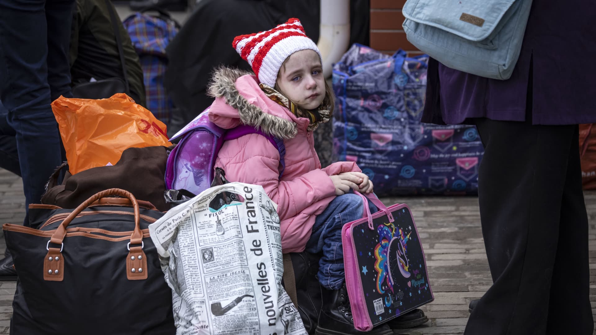 A young girl sits on a suitcase before the train leaves the eastern city of Kramatorsk, in the Donbas region on April 3, 2022.