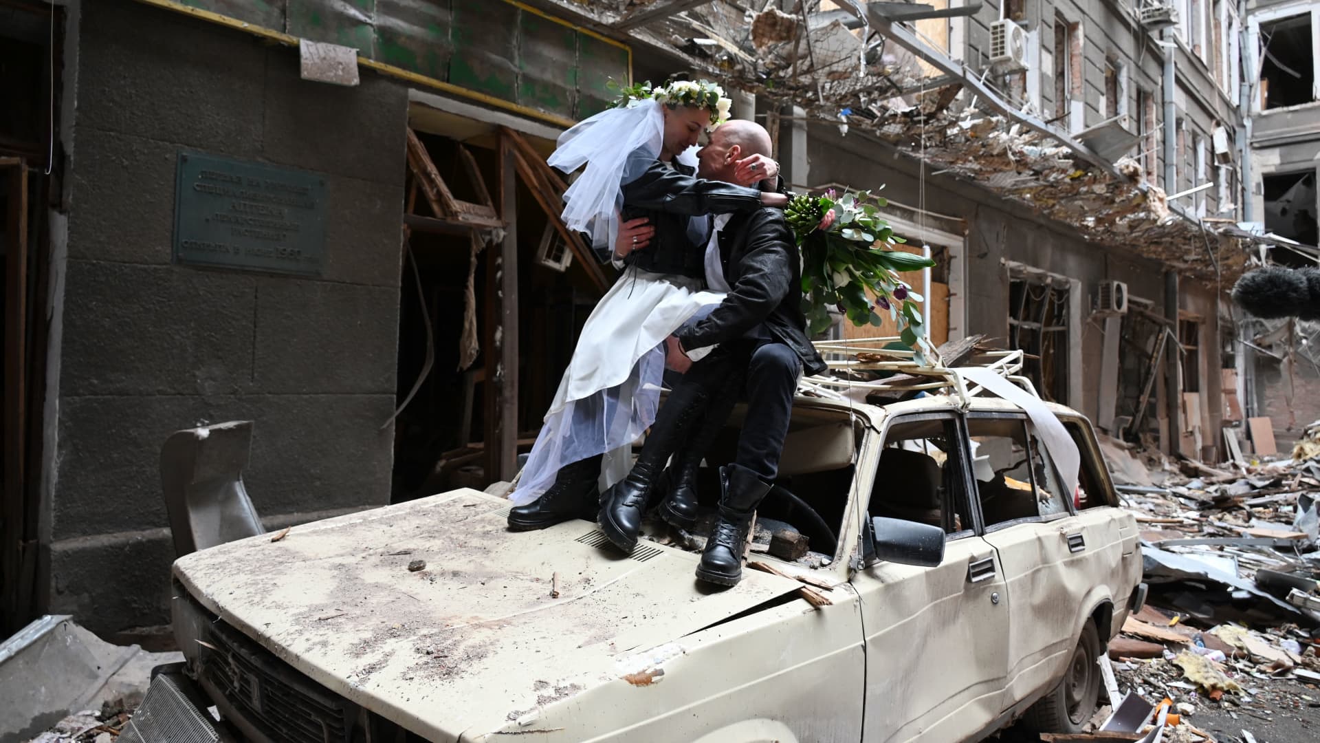 The newlyweds, medical volunteers, nurse in an oncology clinic and doctor before the start of the Russian invasion of Ukraine, Nastya Gracheva and Anton Sokolov, pose for a photograph in a ruined courtyard of shopping and office complex in central Kharkiv on April 3, 2022.