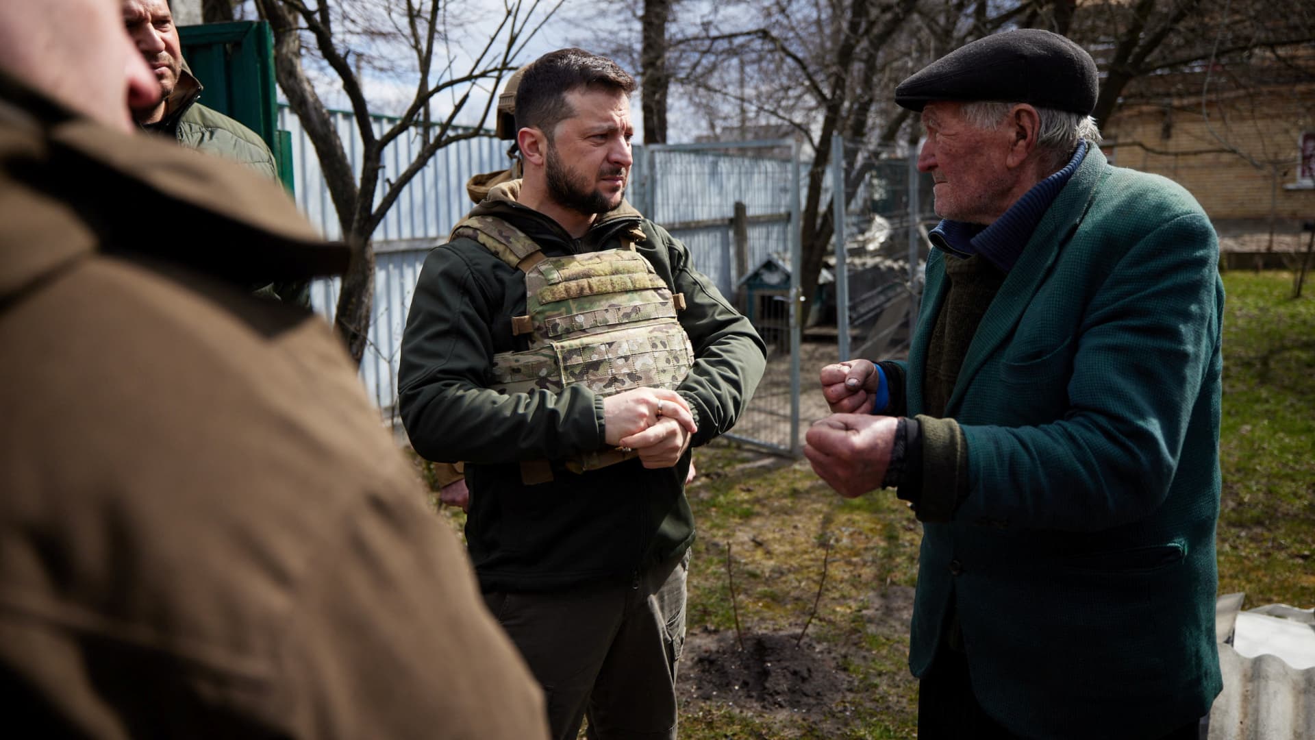 Ukraine's President Volodymyr Zelenskiy speaks to a local resident, as Russia's attack on Ukraine continues, in the town of Bucha, outside of Kyiv, Ukraine April 4, 2022. 