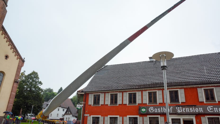 Lahr, Baden-Wuerttemberg, Germany, August 3, 2021: A rotor blade (69 meters, 20 tons) of a wind turbine is transported to the construction site on Langehard over narrow streets and through the village of Sulz.