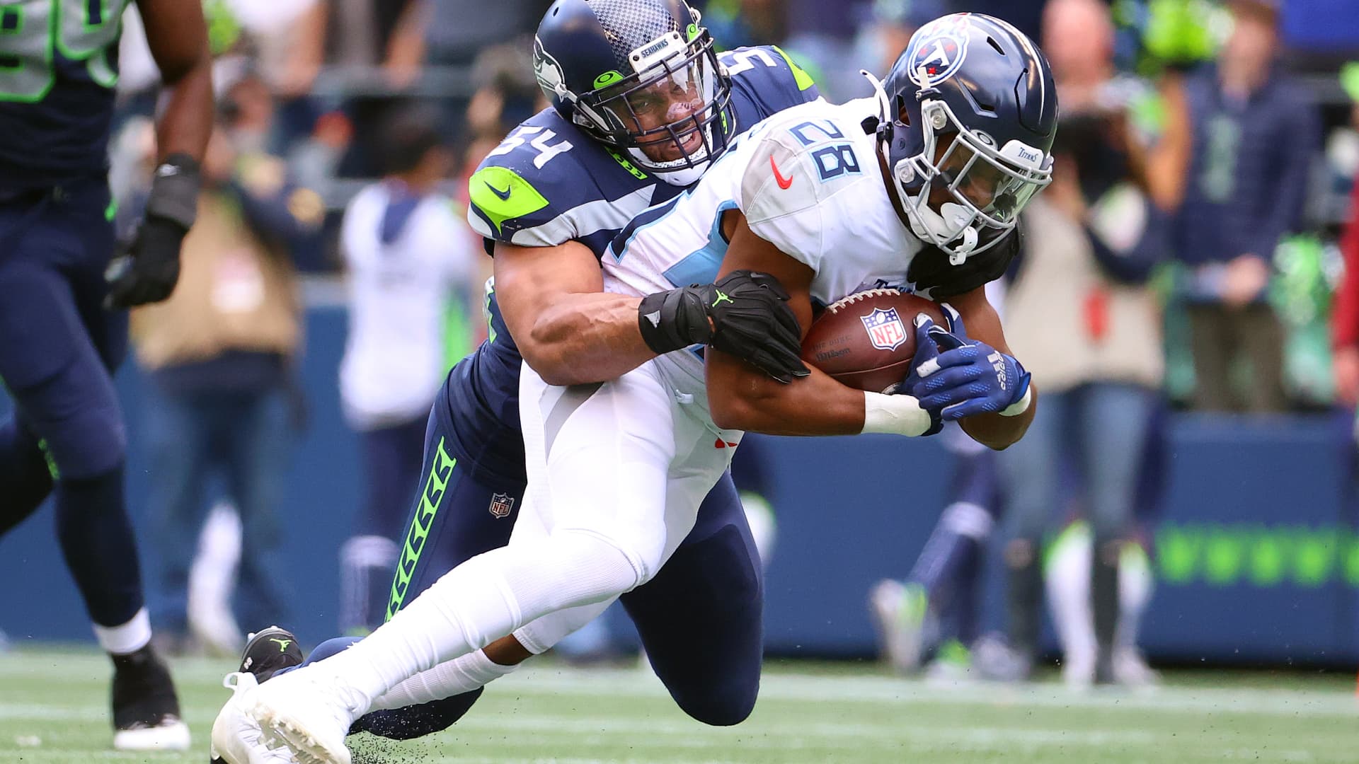 Jeremy McNichols #28 of the Tennessee Titans is tackled by Bobby Wagner #54 of the Seattle Seahawks during the fourth quarter at Lumen Field on September 19, 2021 in Seattle, Washington.