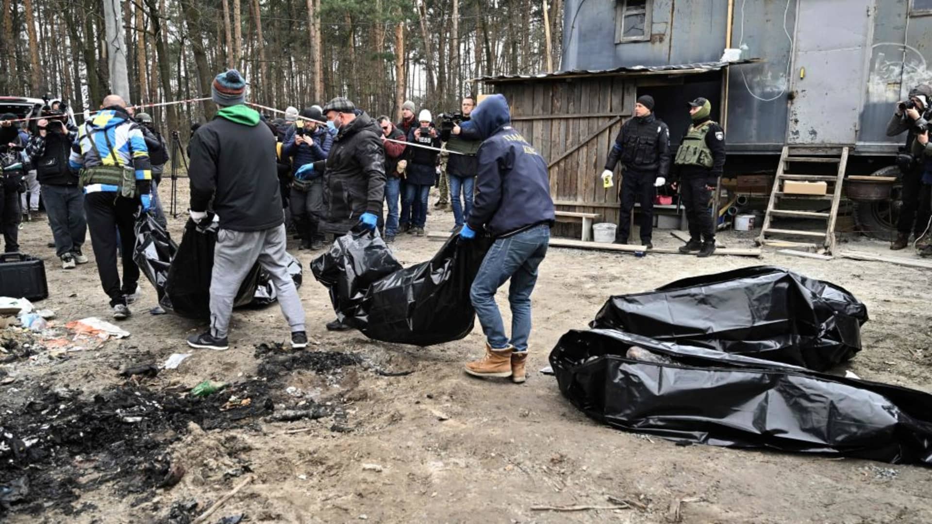 EDITORS NOTE: Graphic content / City workers carry body bags with six partially burnt bodies found in the town of Bucha on April 5, 2022, as Ukrainian officials say over 400 civilian bodies have been recovered from the wider Kyiv region, many of which were buried in mass graves.