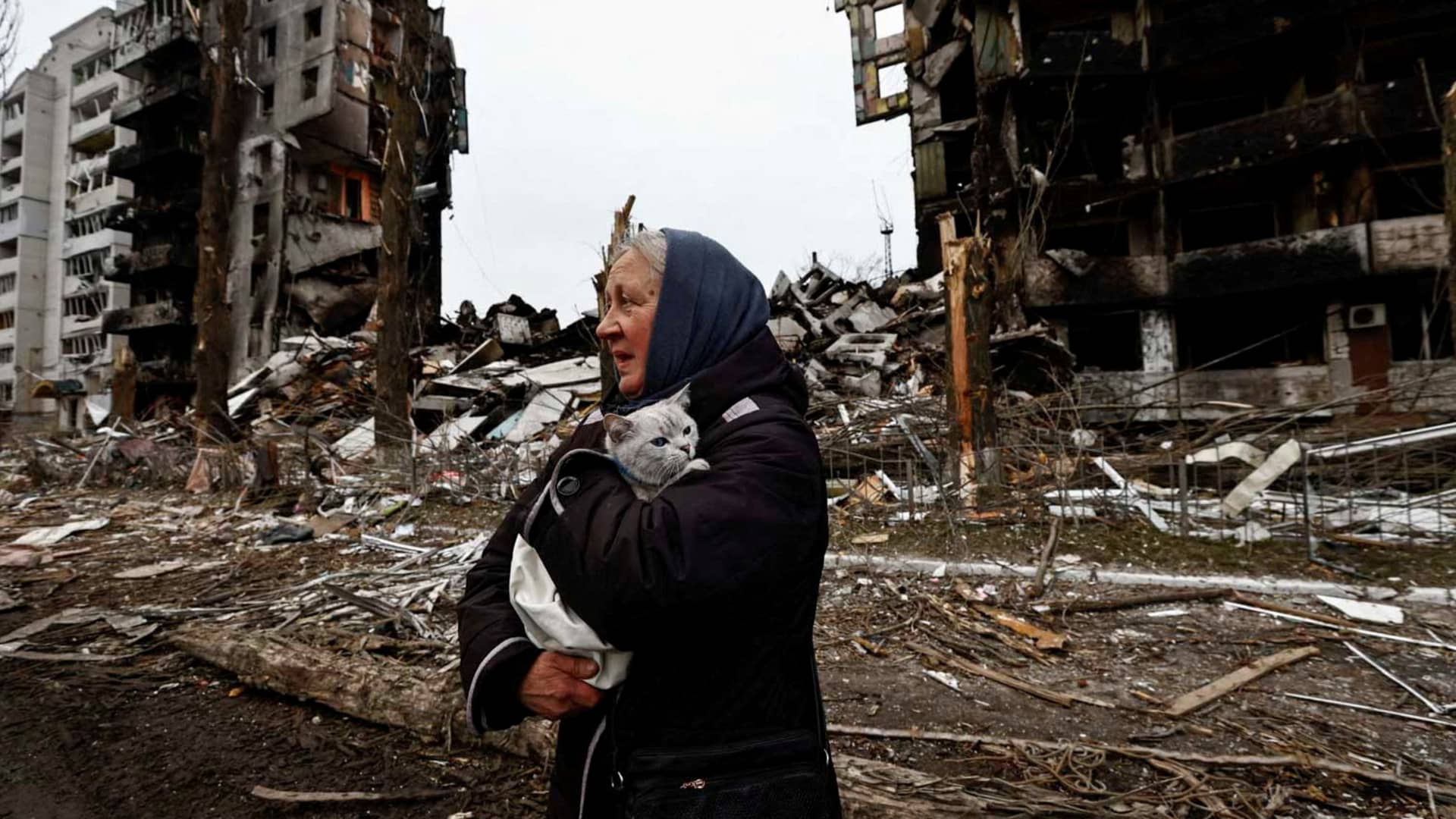 A woman carries her cat as she walks past buildings that were destroyed by Russian shelling in Borodyanka in the Kyiv region, April 5, 2022.