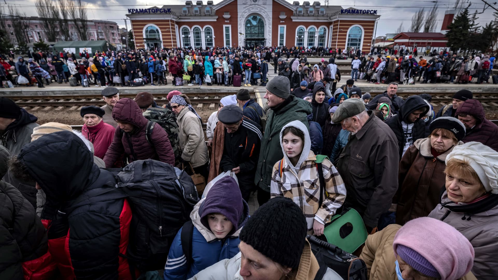 Families walk on a platform to board a train at Kramatorsk central station as they flee the eastern city of Kramatorsk, in the Donbass region on April 5, 2022.