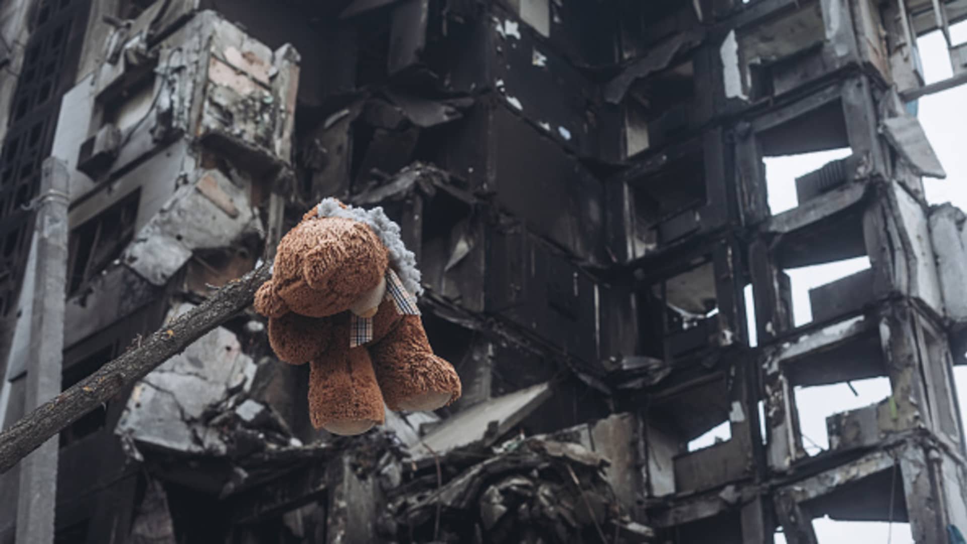 Borodyanka, UKRAINE - APRIL 6: A teddy bear hanging from a tree in front of a building bombed by the Russian army in Borodyanka (Ukraine), 6 April 2022.