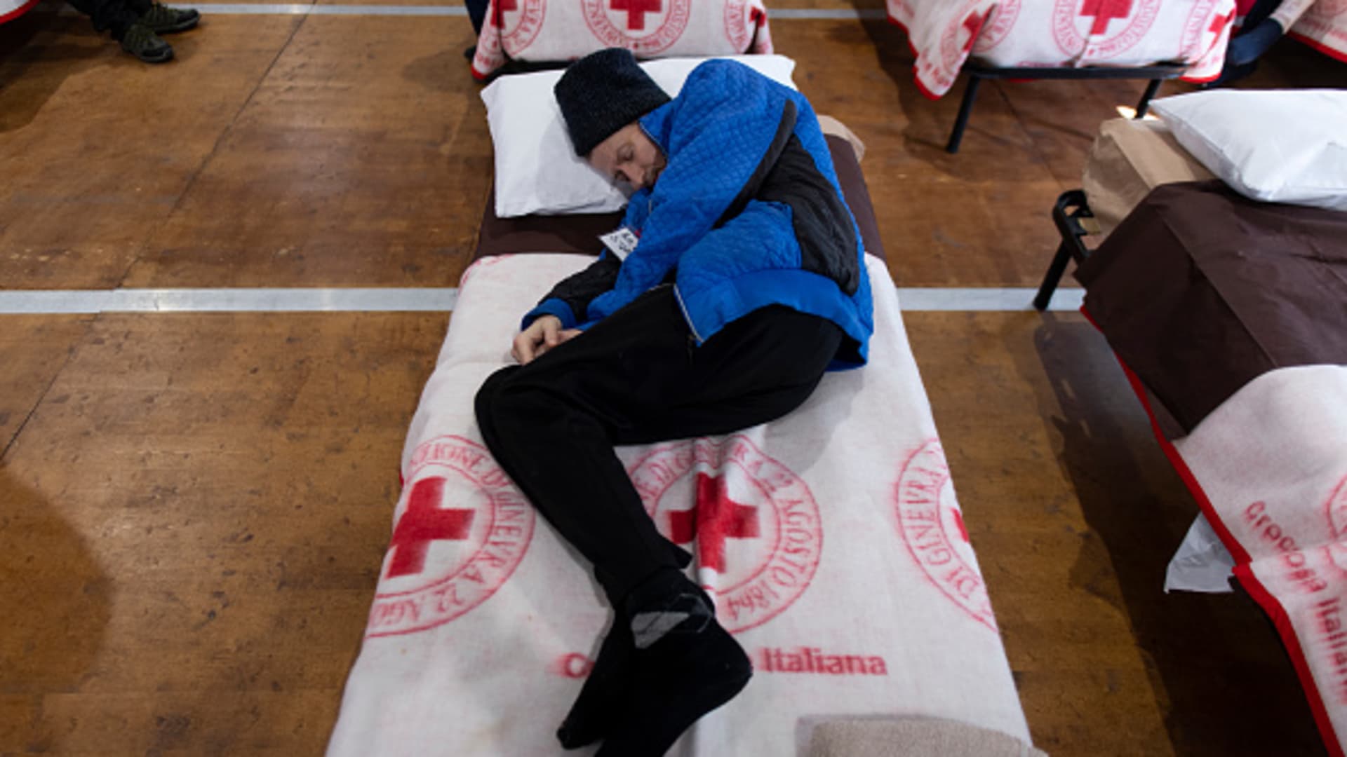 Ukrainian refugee sleeps on a bed inside the Red Cross Headquarters on April 7, 2022 in Settimo Torinese near Turin, Italy. 