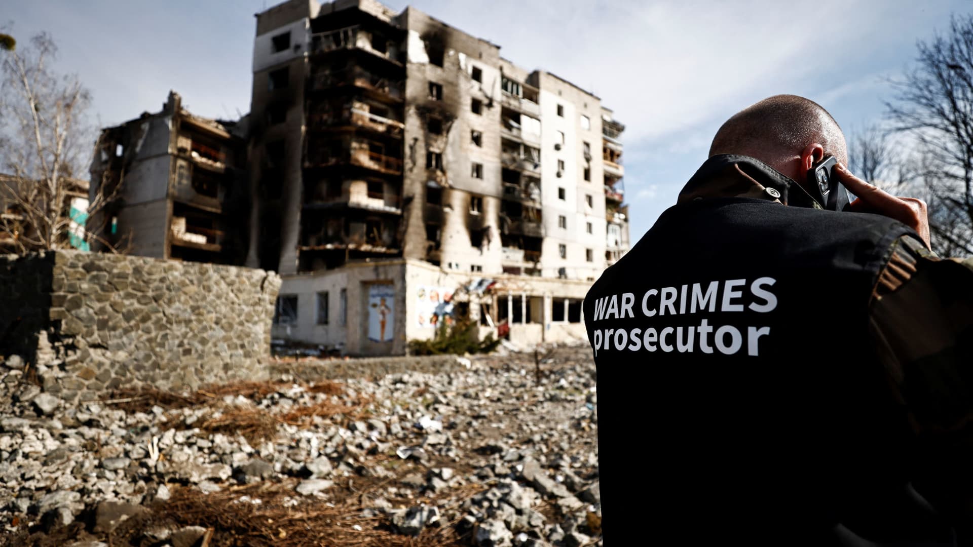 War crime prosecutor's team member speaks on the phone next to buildings that were destroyed by Russian shelling, amid Russia's Invasion of Ukraine, in Borodyanka, Kyiv region, Ukraine April 7, 2022.