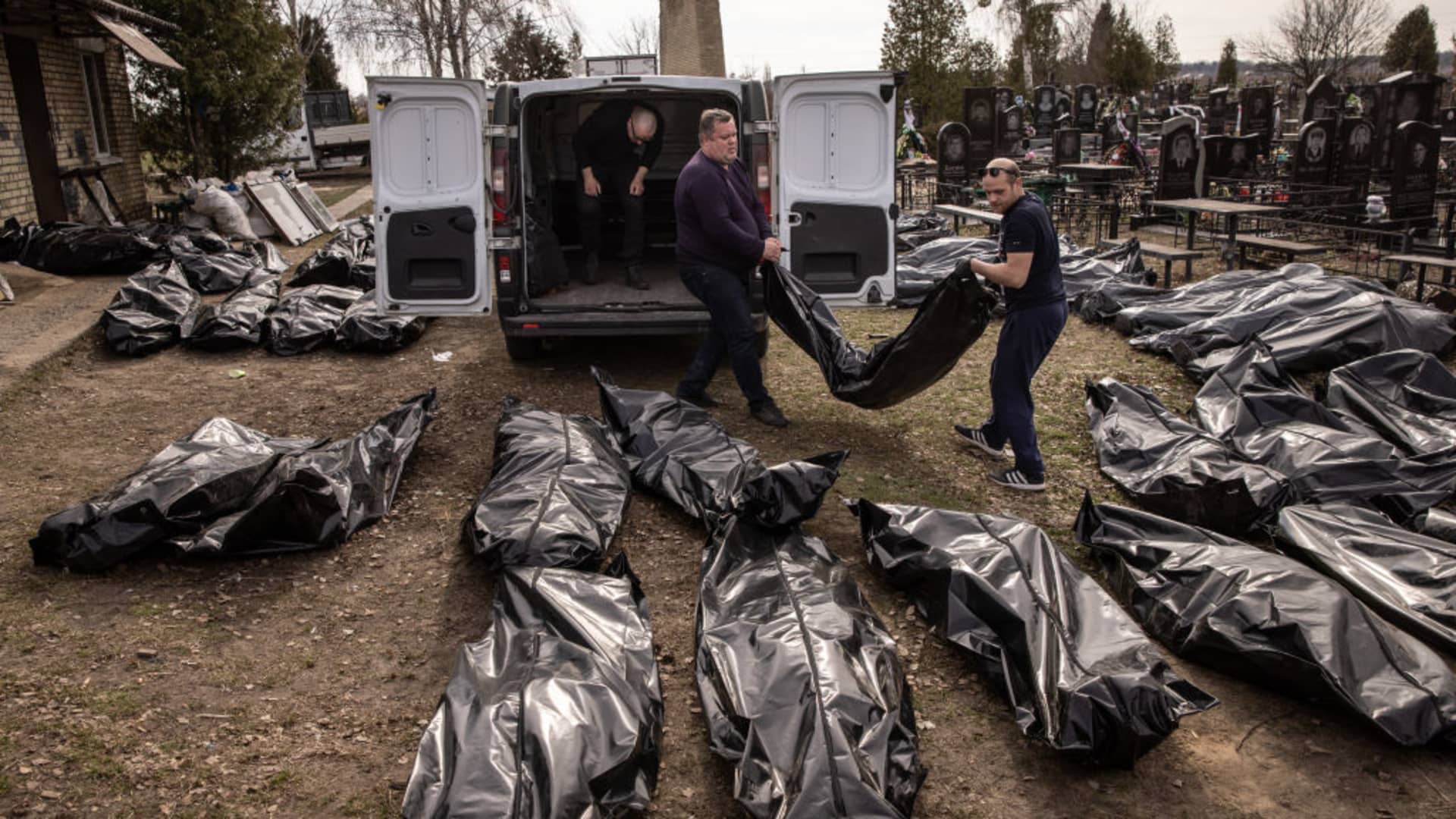 EDITOR'S NOTE: Graphic content. Cemetery workers unload bodies of civilians killed in and around Bucha before they are transported to a morgue at a cemetery on April 7, 2022.