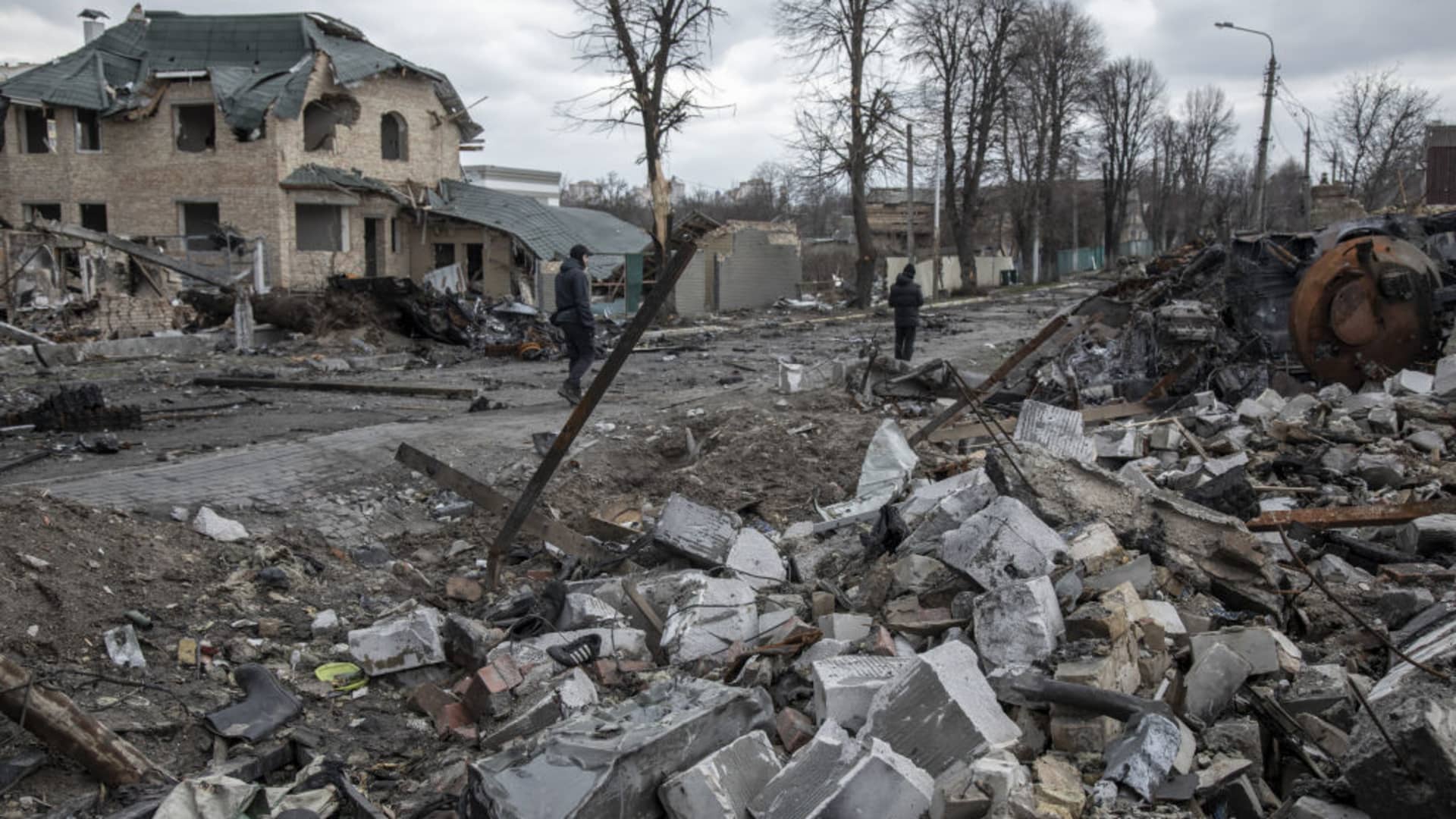 Civilians walk amid the destruction on a street in the town of Bucha, on the outskirts of Kyiv, after the Ukrainian army secured the area following the withdrawal of the Russian army.