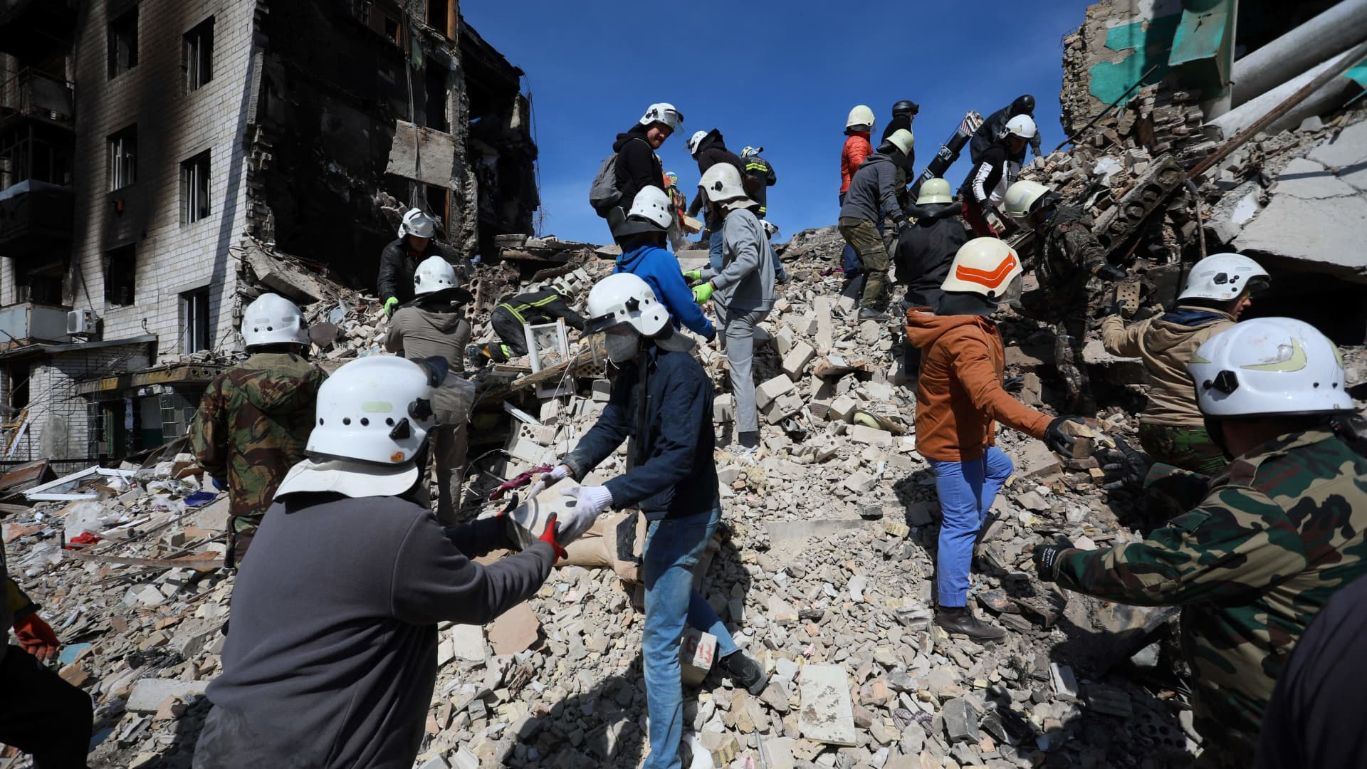 Volunteers help rescuers to remove rumbles of a damaged building in the town of Borodyanka, northwest of Kyiv, on April 7, 2022, during Russia's military invasion launched on Ukraine.