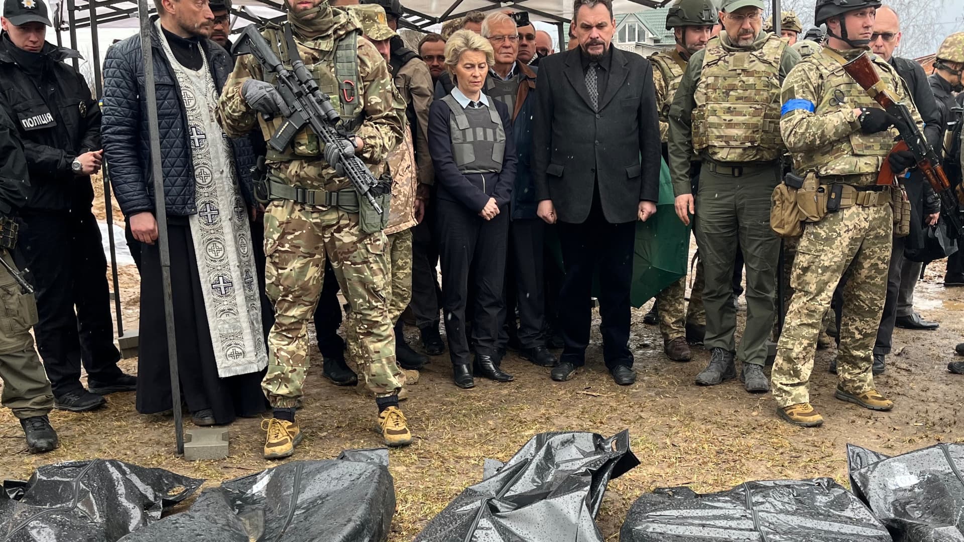 EU Commission President Ursula von der Leyen (M) and EU High Representative for Foreign Affairs Josep Borrell (behind) and Denys Shmyhal (green cap), Prime Minister of Ukraine, stand behind body bags in Bucha on April 8th, 2022.
