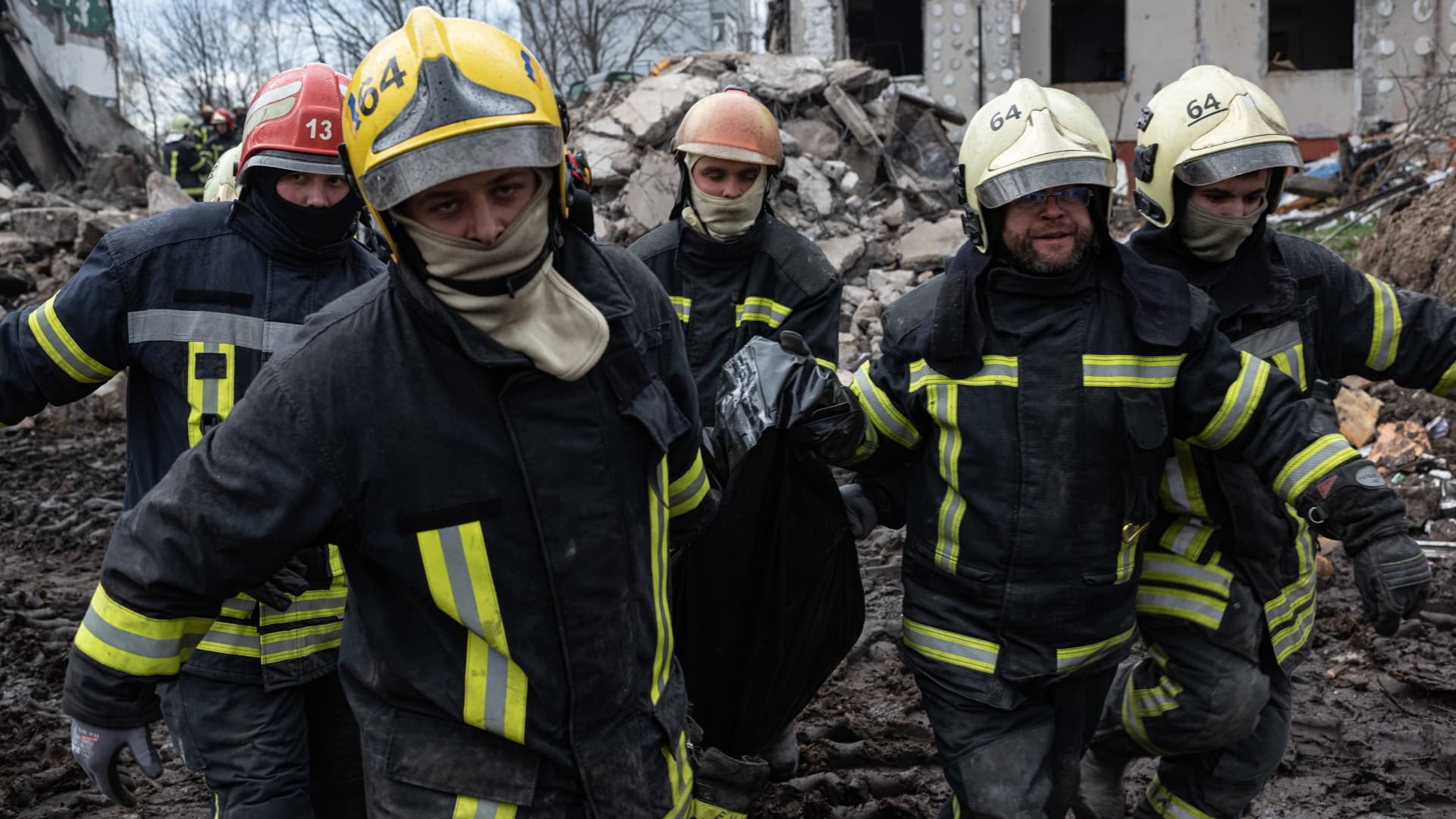 Rescue workers carry the body of a man who was found among the rubble of a destroyed apartment building, on April 9, 2022 in Borodianka, Ukraine. 