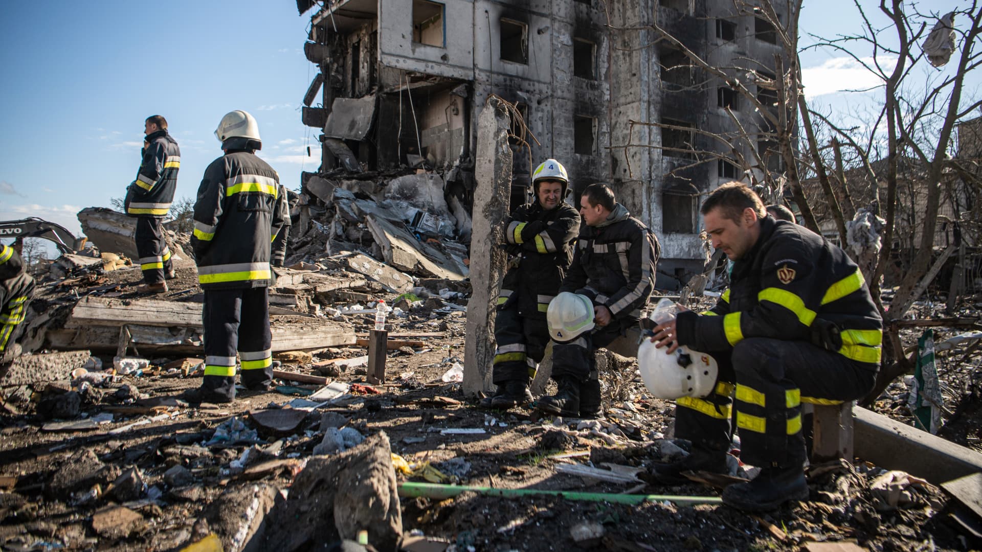 Firefighters rest while clearing debris from a building that collapsed due to shelling in Borodyanka, a town in Kyiv Oblast.