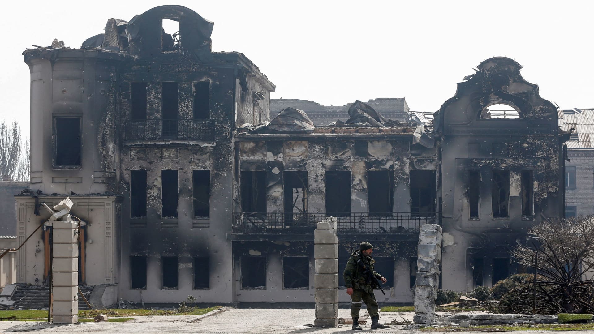 A service members of pro-Russian troops stands near a building burnt during Ukraine-Russia conflict in the southern port city of Mariupol, Ukraine April 10, 2022. 