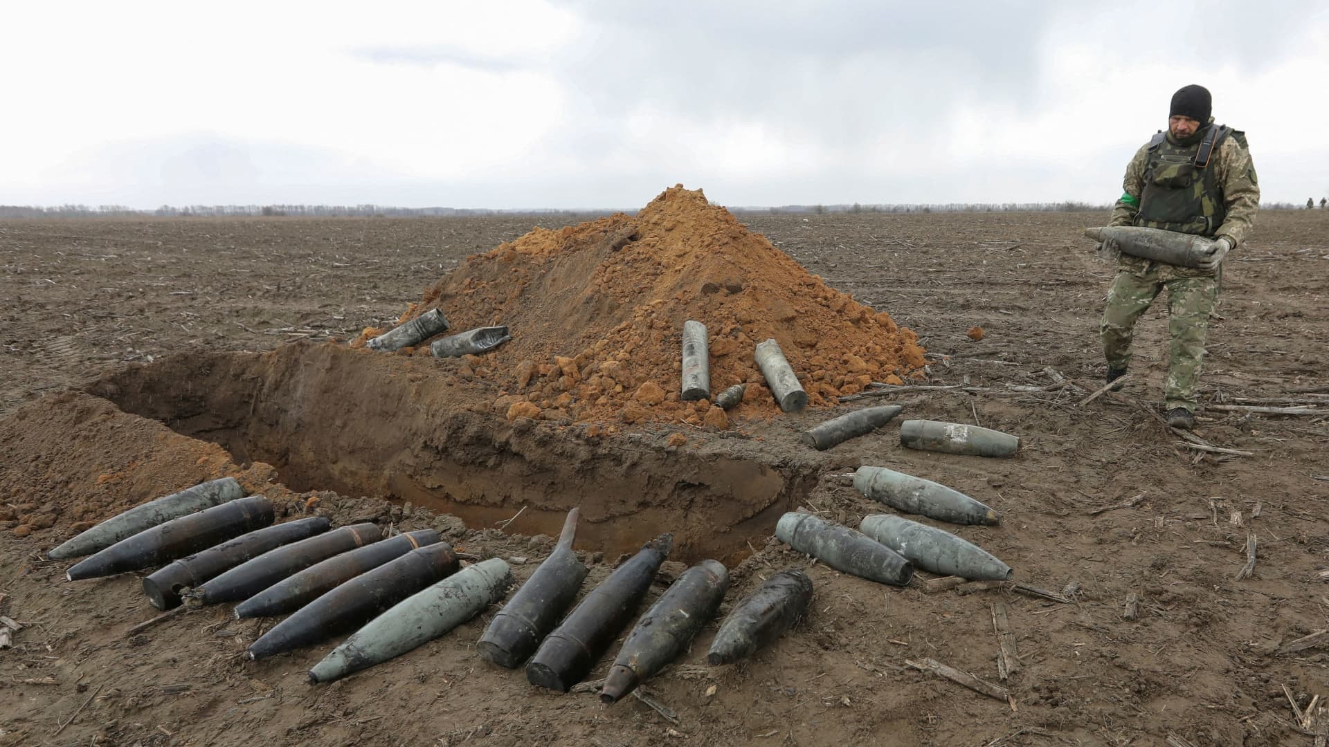A military sapper carries an unexploded shell left after Russia's invasion near the village of Motyzhyn, in Kyiv region, Ukraine April 10, 2022. 