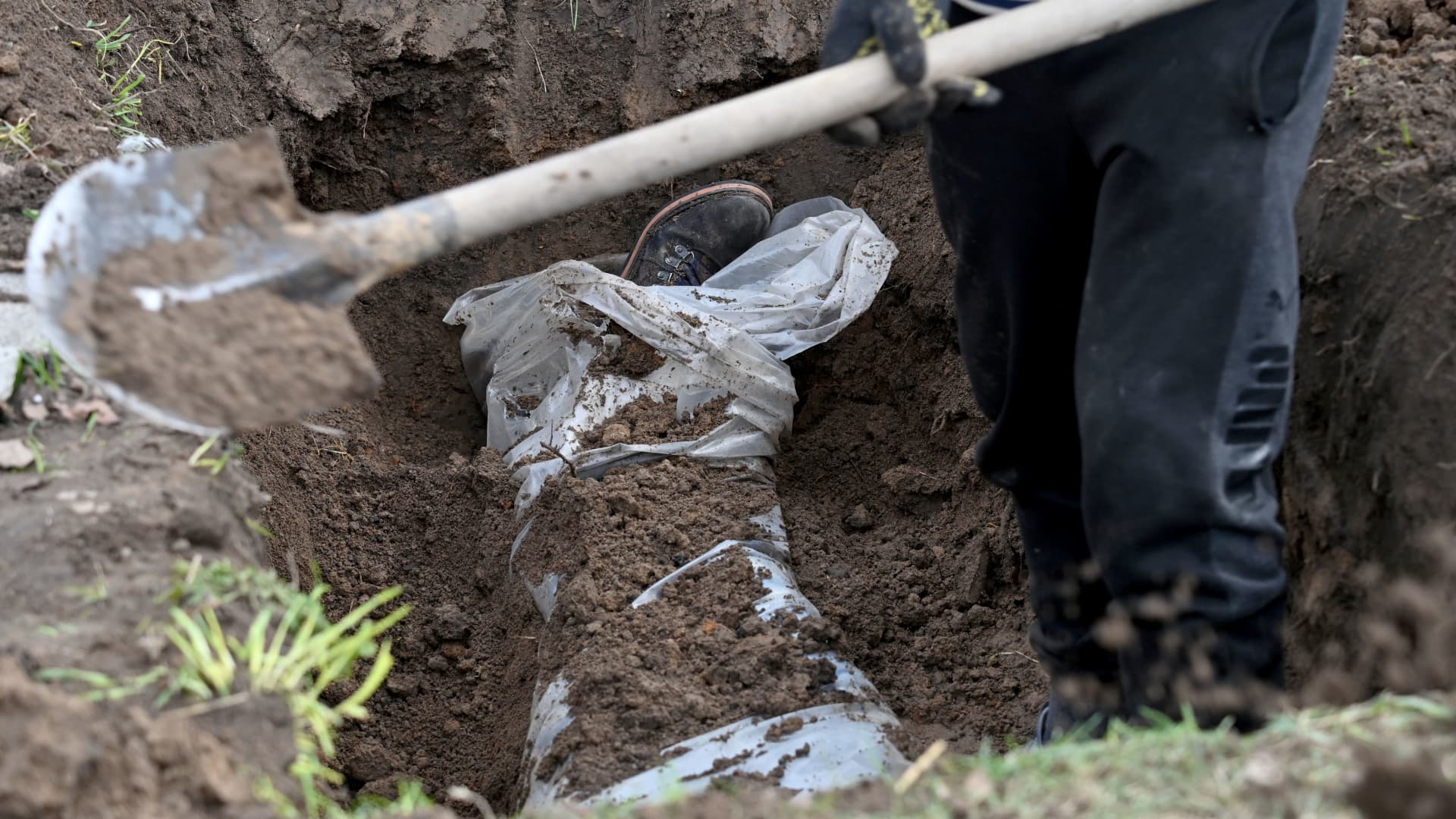 EDITORS NOTE: Graphic content / A communal worker exhumes a body of a man buried near his house in Andriivka village, Kyiv region, on April 11, 2022.