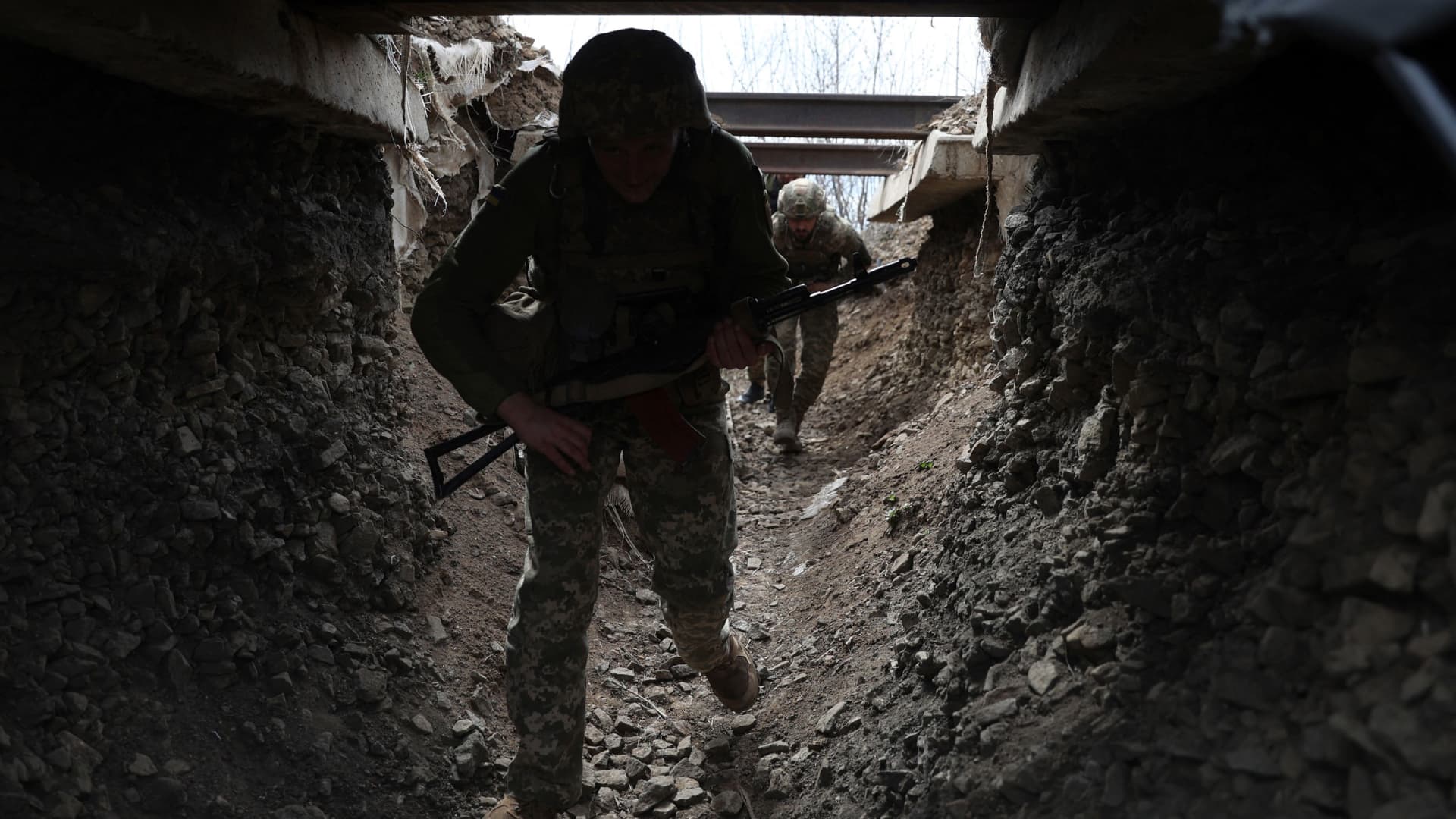 Ukrainian soldiers walk through a tunnel of a trench on the front line with Russian troops in Luhansk region on April 11, 2022.