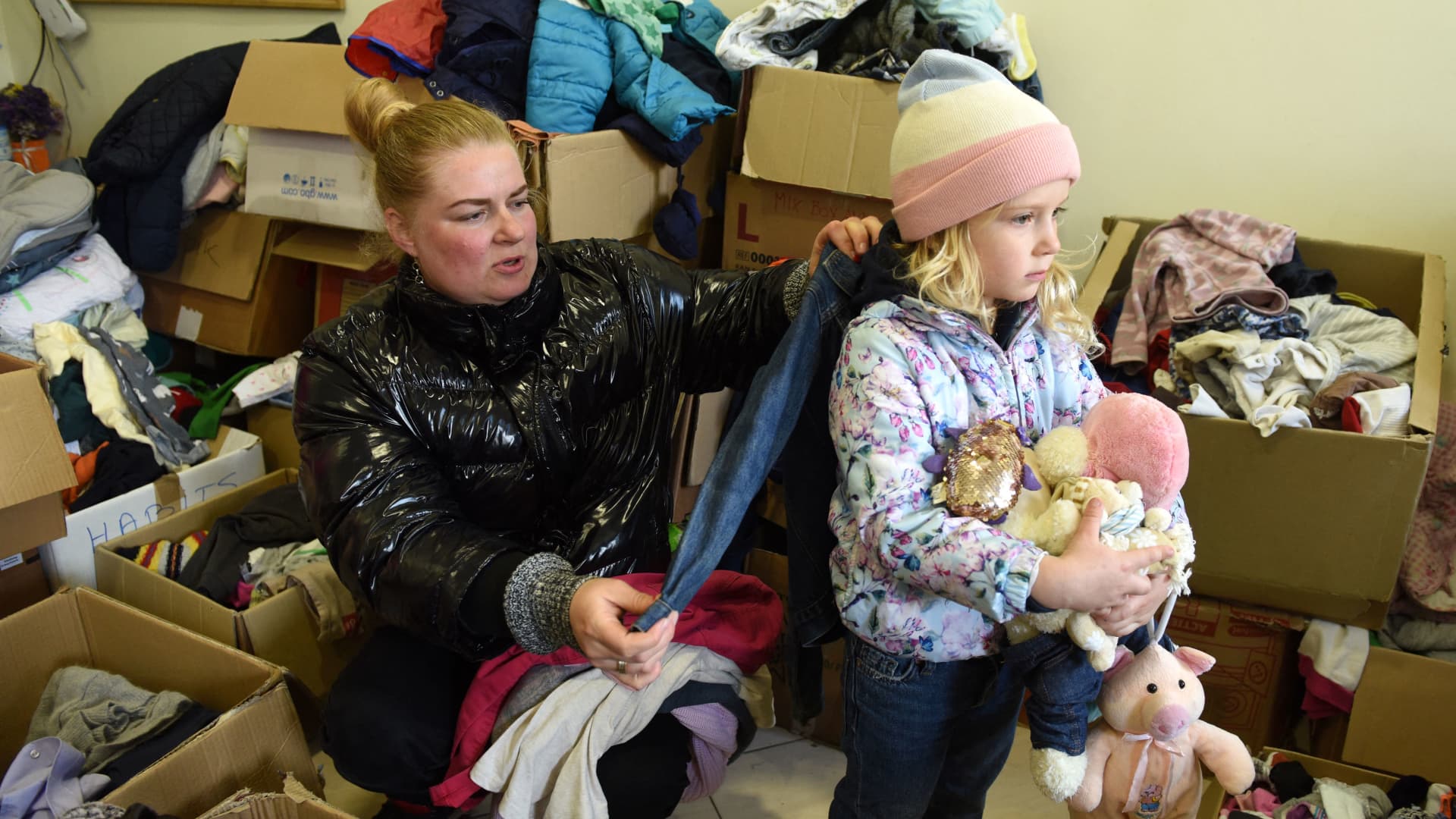 Displaced Ukrainian dentist Yana and her daughter, five-year-old Maya, look for clothes and toys at an aid distribution center in Ukraine's western city of Lviv on April 11, 2022.