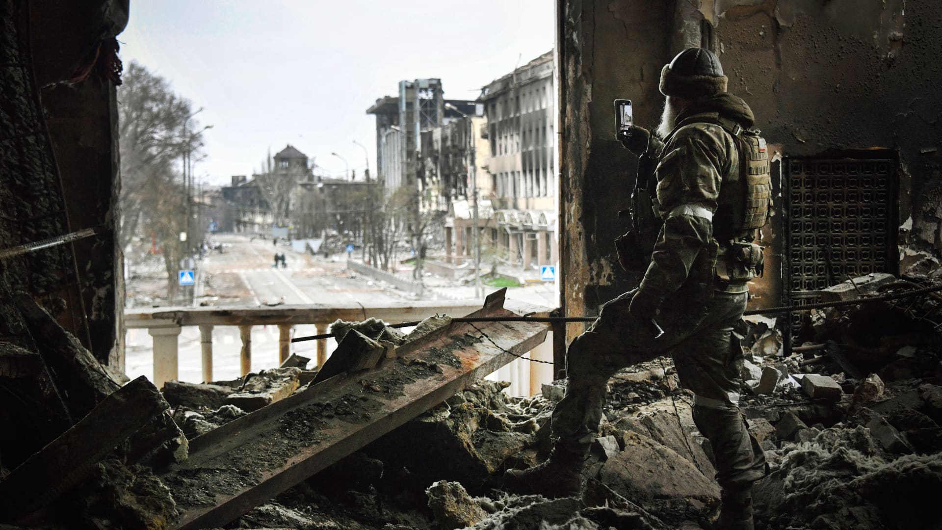 A Russian soldier patrols the Mariupol drama theatre, hit March 16 by an airstrike, on April 12, 2022 in Mariupol, as Russian troops intensify a campaign to take the strategic port city. Editor's note: This picture was taken during a trip organized by the Russian military.