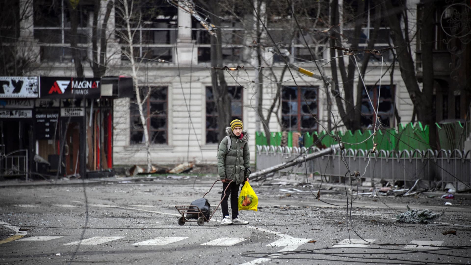 A young man walks in a street of Mariupol on April 12, 2022. Andrii Nebitov, head of Kyiv region police, says more than 3,050 criminal proceedings for crimes committed by the military of the Russian Federation have been opened.