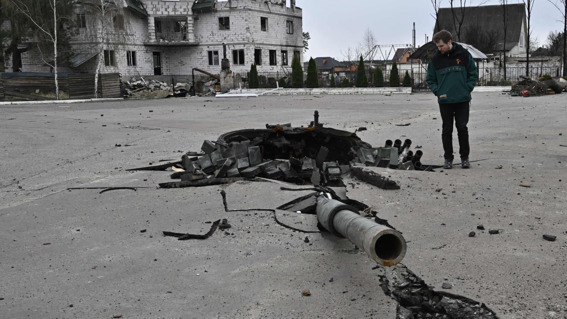 A man walks next to the debris of a destroyed Russian tank near the village of Zalissya, northeast of Kyiv, on April 12, 2022.