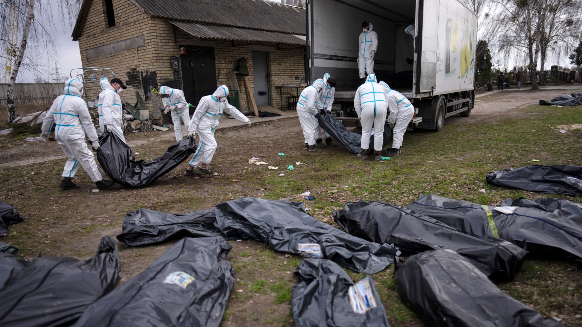 Editor's note: Graphic image. Volunteers load bodies of civilians killed in Bucha onto a truck to be taken to a morgue for investigation, in the outskirts of Kyiv, Ukraine, Tuesday, April 12, 2022.