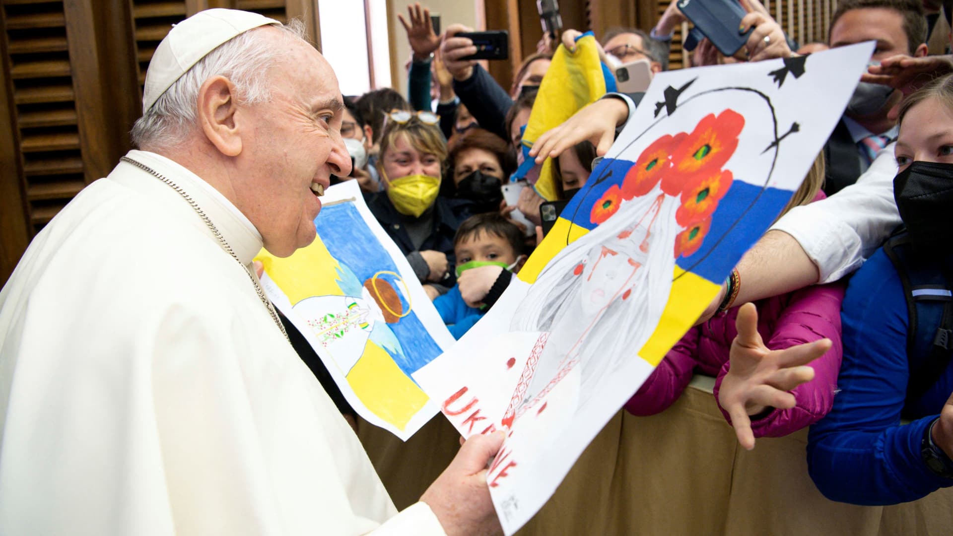 Pope Francis receives Ukraine war-themed drawings during the weekly general audience at the Paul VI Hall at the Vatican, April 13, 2022. 