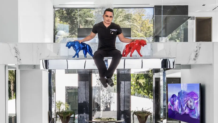 Dr Khadavi seated on top of the DJ booth that rises from beneath the floor at his spec house in Bel Air.