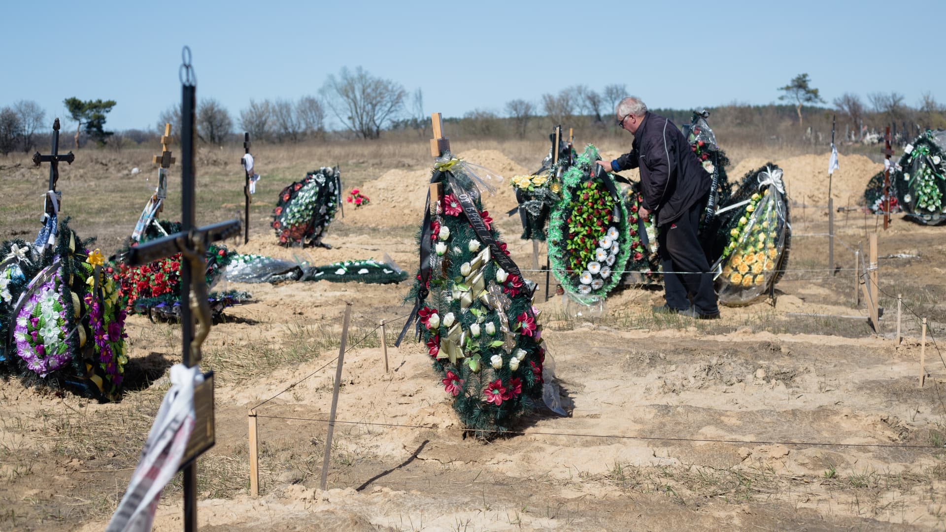 A man fixes the wreath on the grave in a cemetery on April 14, 2022 in Hostomel, Ukraine.