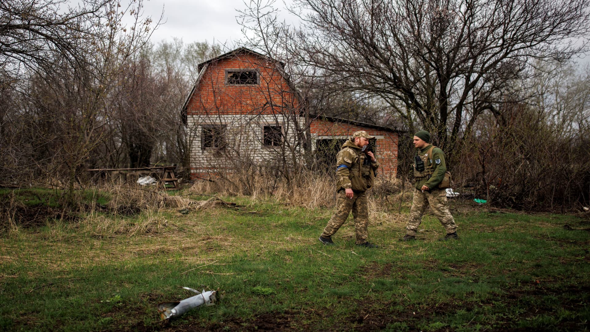 Ukrainian soldiers stand outside an abandoned Russian outpost, amid Russia's attack on Ukraine, in the village of Husarivka, in Kharkiv region, Ukraine, April 14, 2022.