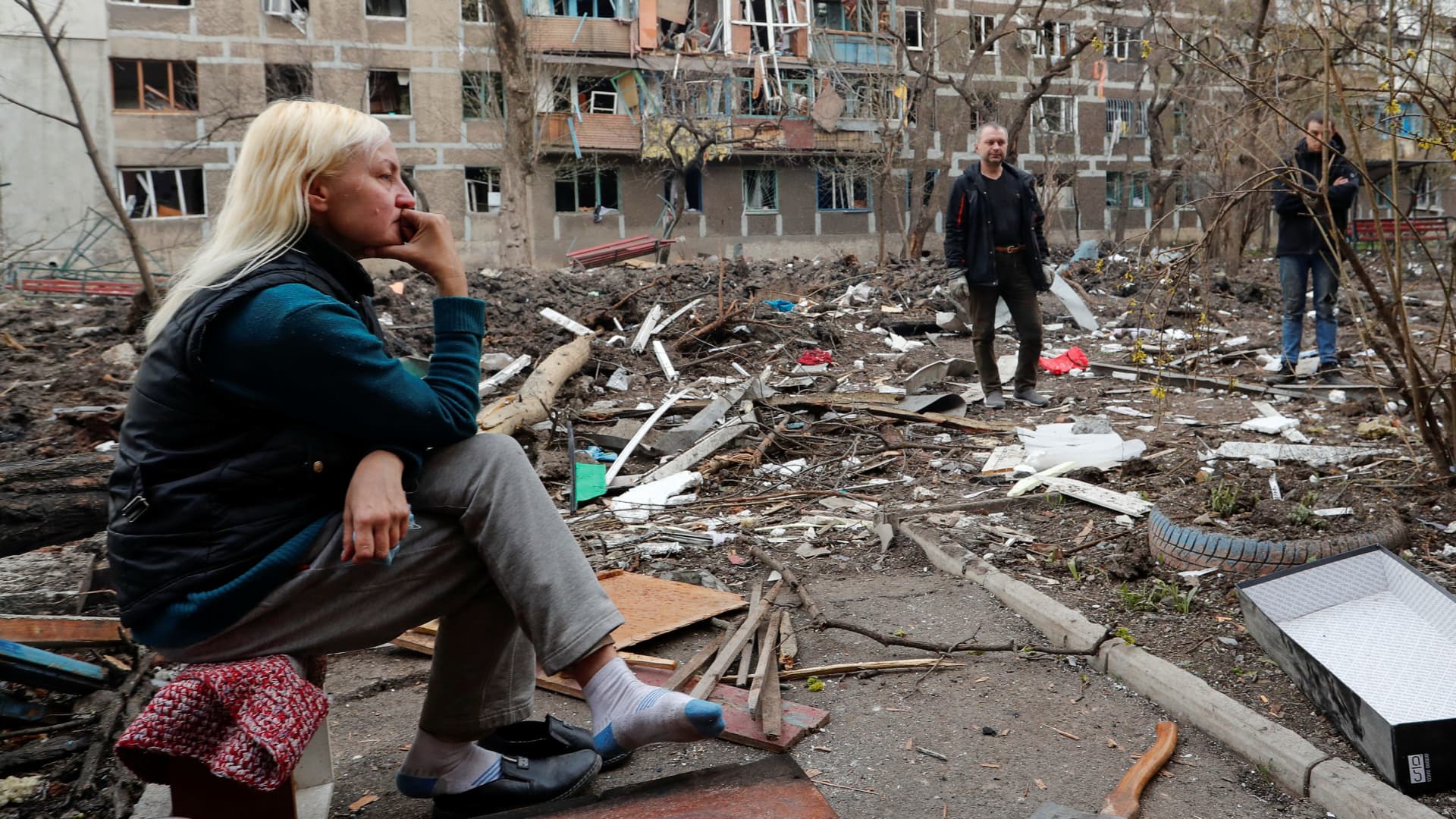 Local resident gather in a courtyard near a block of flats heavily damaged during Ukraine-Russia conflict in the southern port city of Mariupol, Ukraine April 18, 2022.