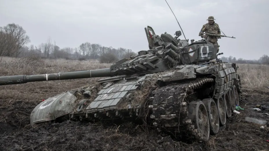 A member of the Ukrainian Territorial Defense Forces stands on a damaged Russian tank on the outskirts of Nova Basan village in Ukraine on April 01, 2022.