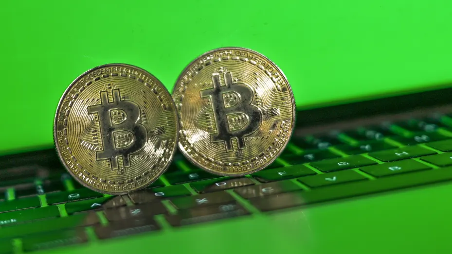 Illustrative image of two commemorative bitcoins with a green background.