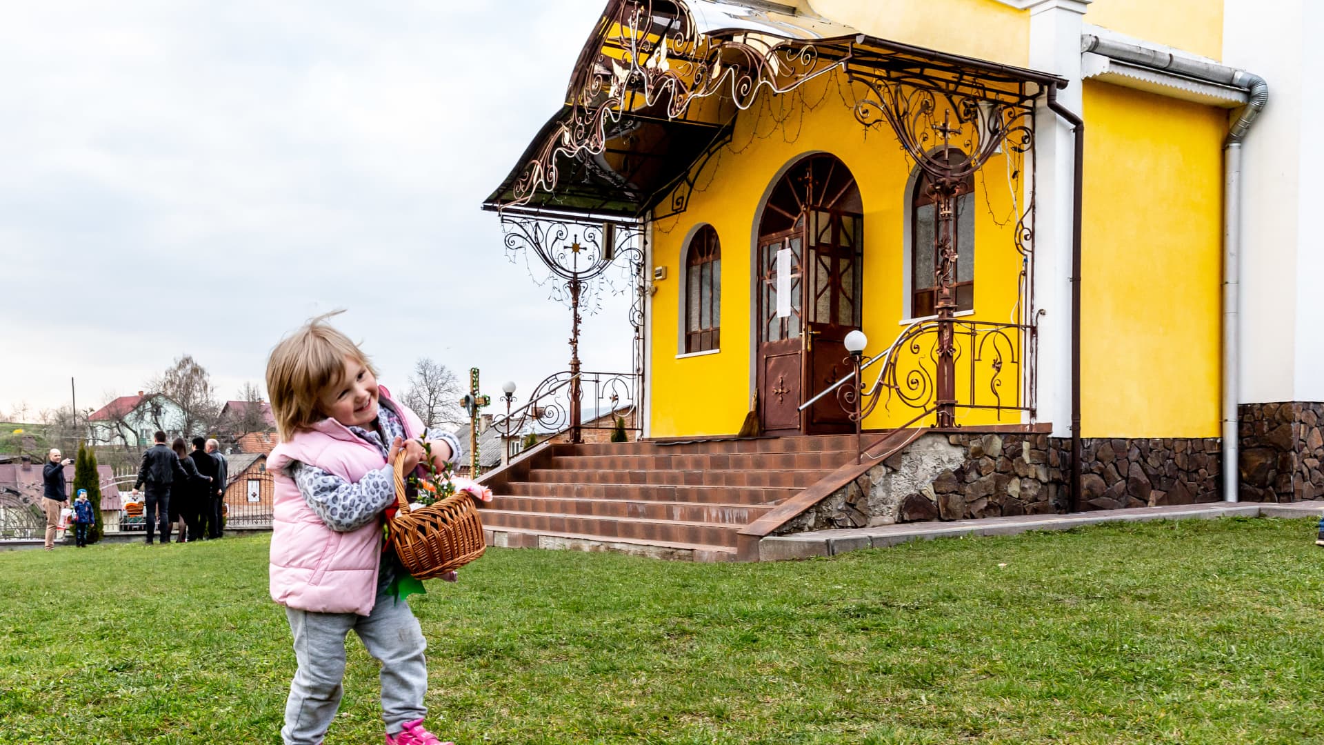 Many have been internally displaced and are taking temporary shelter at the Greek Catholic church in Nadyby, Lviv. Seen here is a young Ukrainian girl from Donetsk skipping along with her Easter food basket in front of the church.
