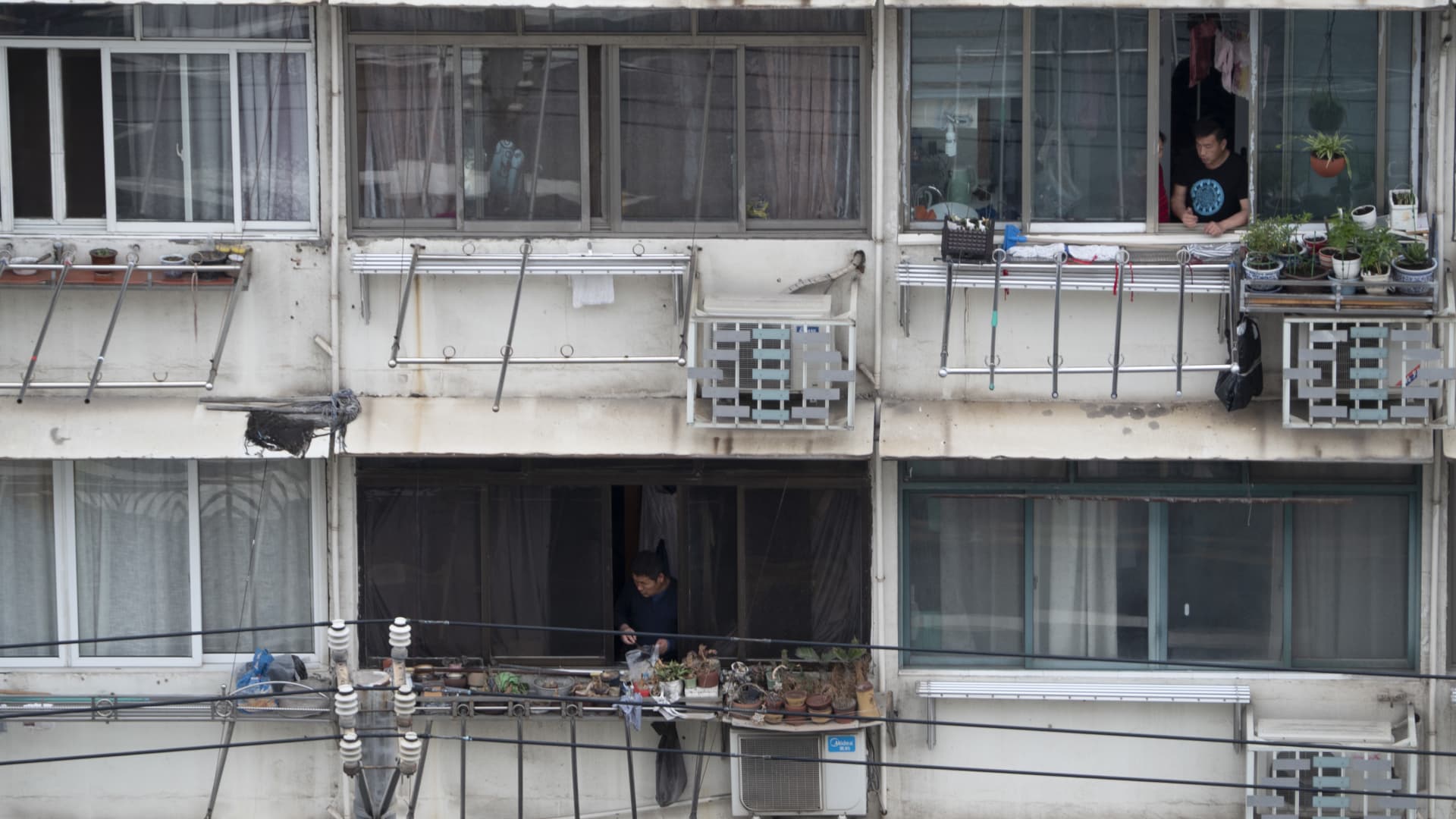 Resident in a so-called containment building looking out of their balconies on April 24, 2022 in Shanghai, China as the city battles its worst Covid outbreak since the start of the pandemic.