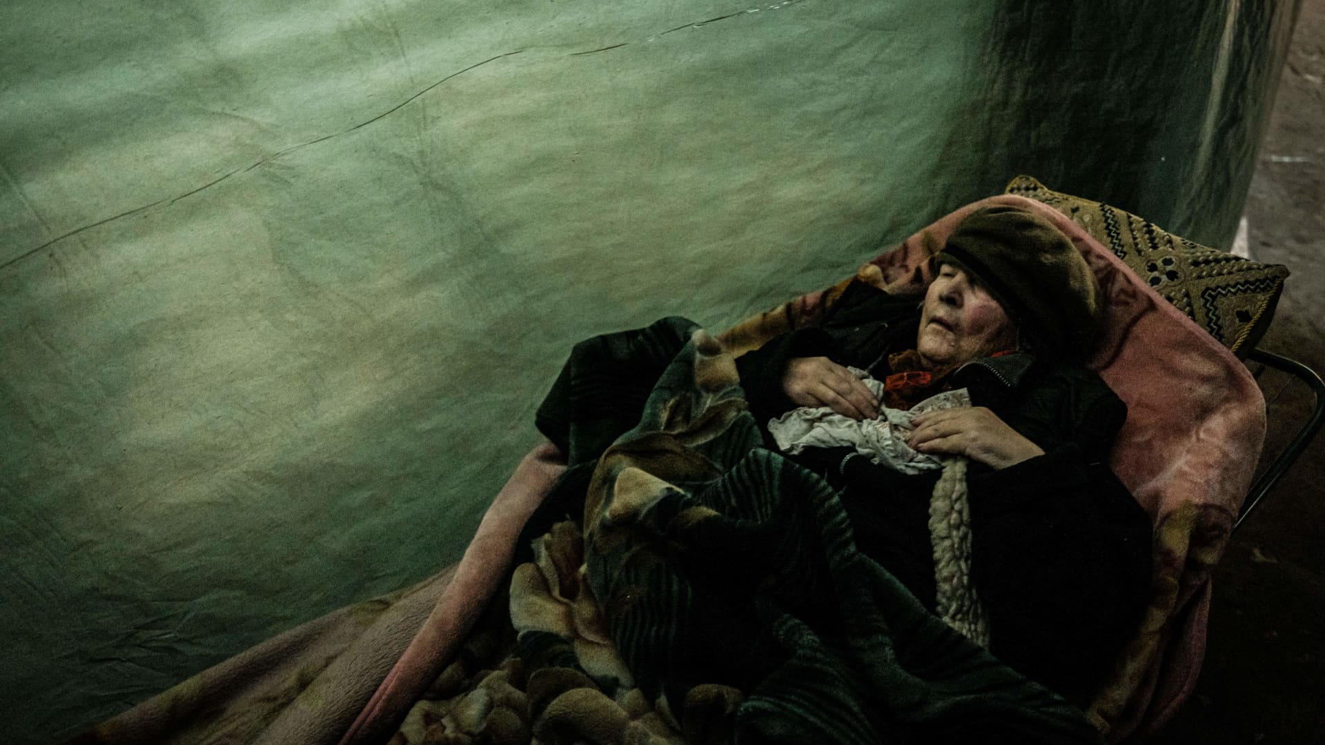 TOPSHOT - An internally displaced 92-year-old woman lays downs as she waits for Ukraine Red Cross to evacuate her in a bunker at a factory in Severodonetsk, eastern Ukraine, on April 22, 2022 amid the Russian invasion of Ukraine.