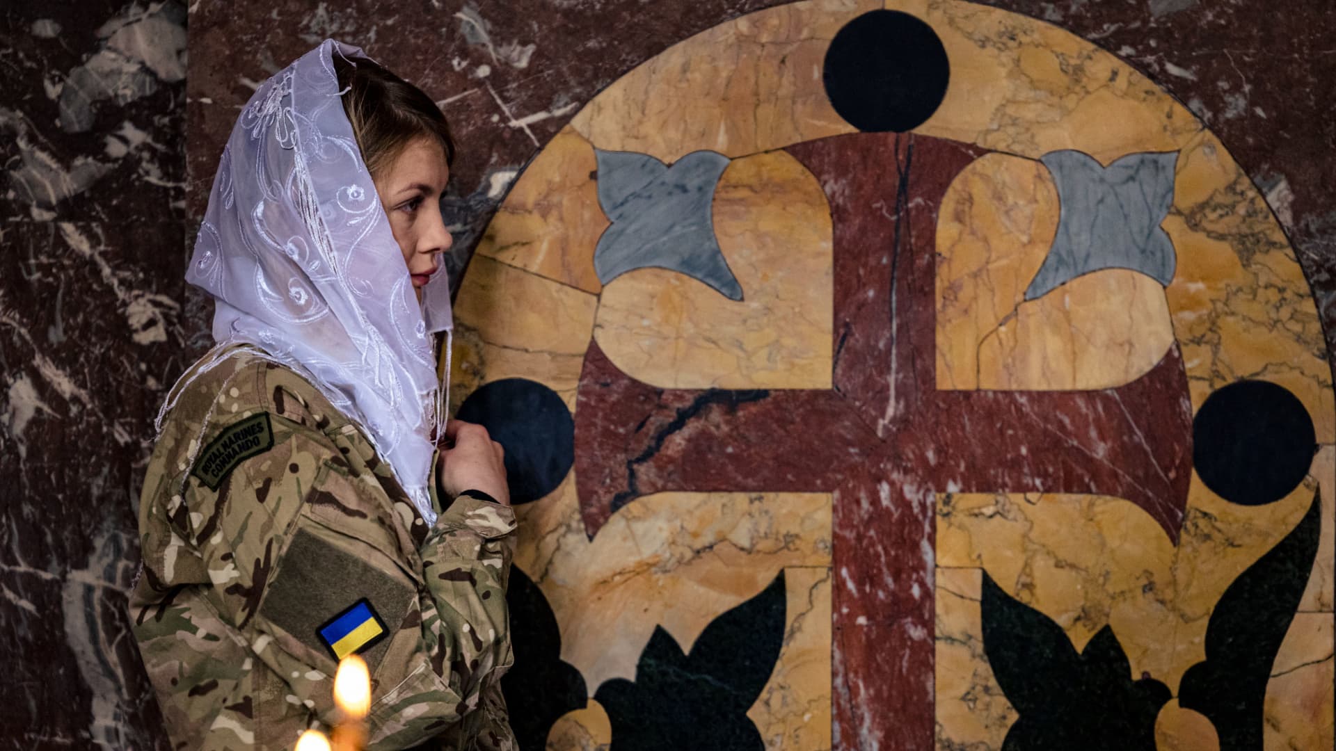 A female Ukrainian soldier crosses herself during an Orthodox Easter service in St. Volodymyr's Cathedral in Kyiv on April 24, 2022, two months after the start of Russia's invasion of Ukraine.