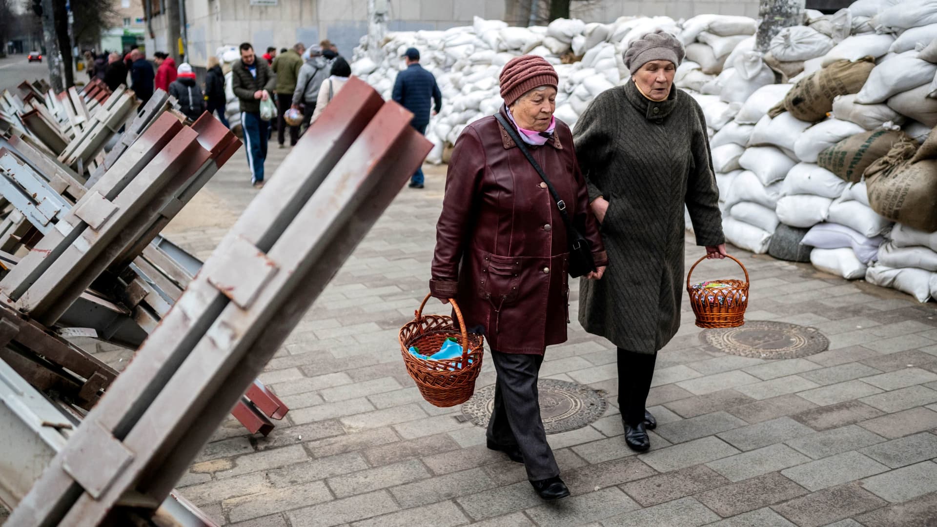 Faithful walk between sandbags and hedgehog anti-tank barricades to attend a blessing of traditional Easter food baskets on Holy Saturday, amid Russia's invasion of Ukraine, in Zhytomyr, Ukraine April 23, 2022.