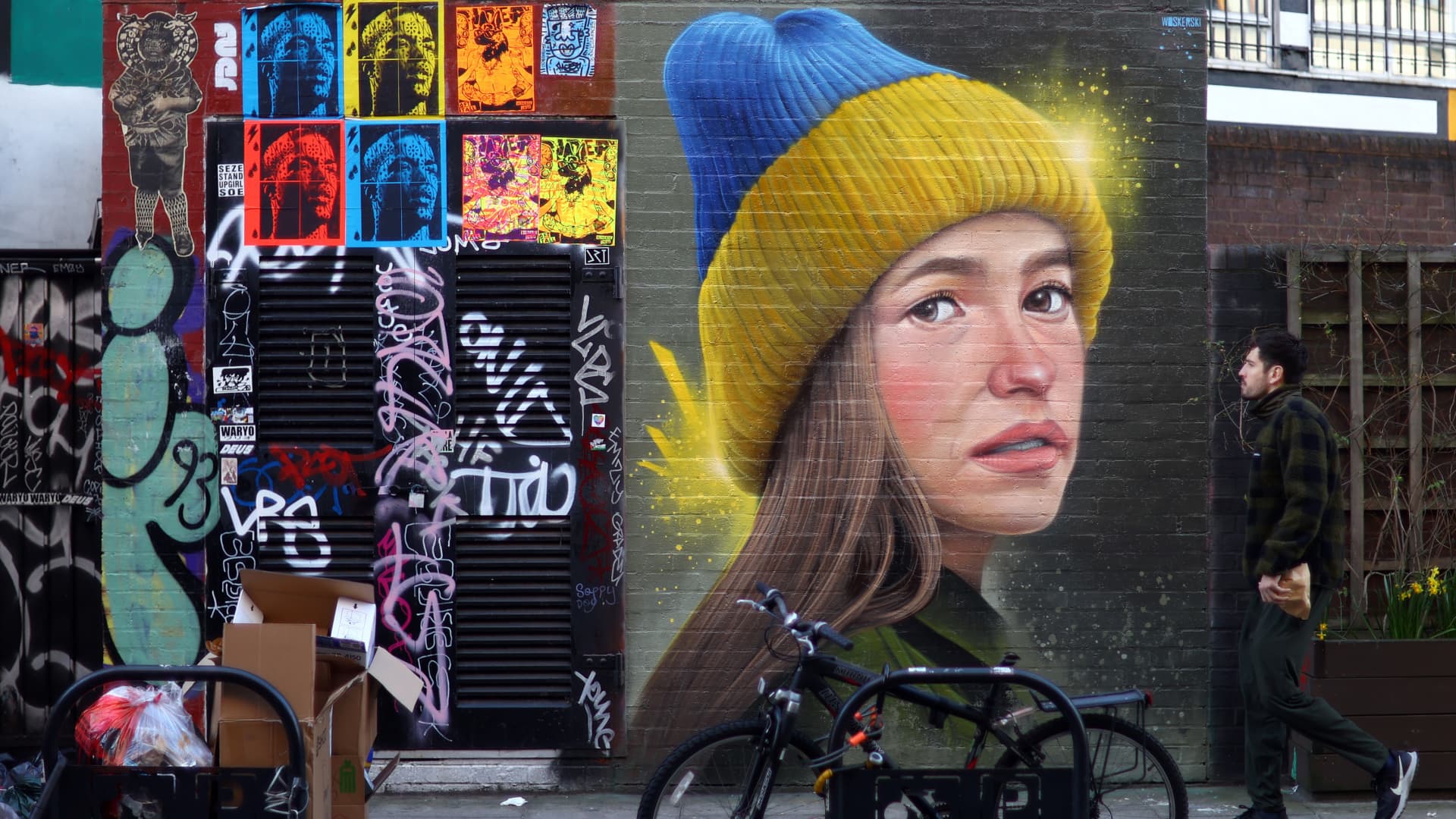 A man walks past a mural in support of Ukraine by artist WOSKerski, as Russia's invasion of Ukraine continues, in London, Britain, March 14, 2022. 