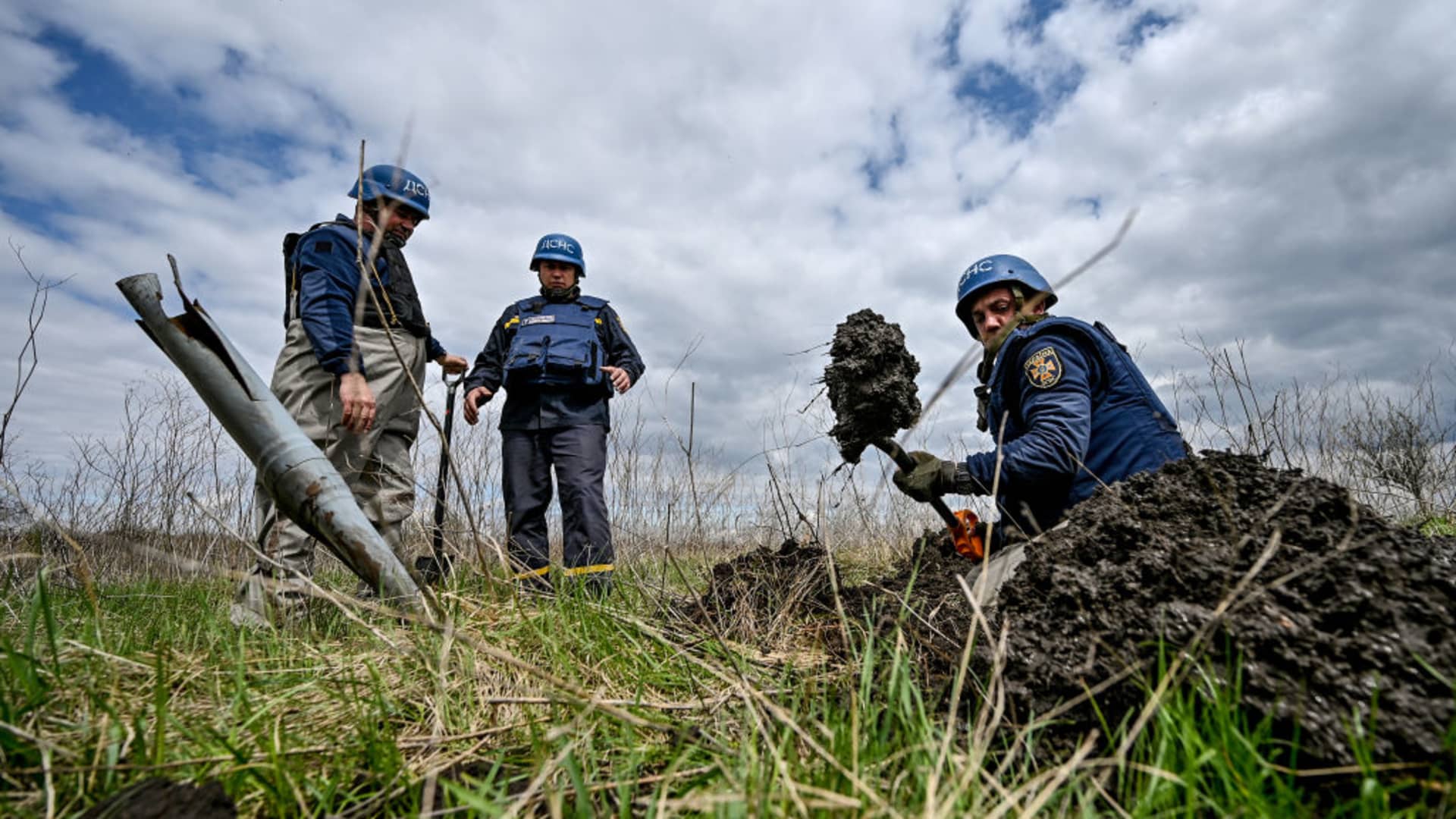 An expert of a State Emergency Service bomb squad digs around the dangerous remains of an Uragan rocket stuck in pastureland during a mine clearance effort, Hryhorivka, Zaporizhzhia Region, southeastern Ukraine.