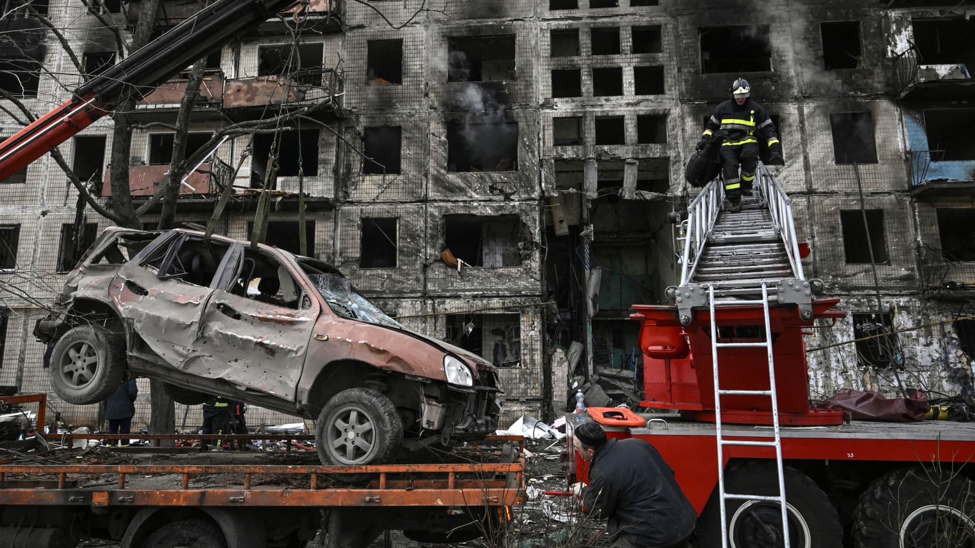 A ruined car is placed on a flatbed lorry from in front of a destroyed apartment building after it was shelled in the northwestern Obolon district of Kyiv on March 14, 2022. - Two people were killed on March 14, 2022, as various neighbourhoods of the Ukraine capital Kyiv came under shelling and missile attacks, city officials said, after the Russia's military invaded the Ukraine on February 24, 2022. (Photo by Aris Messinis / AFP) (Photo by ARIS MESSINIS/AFP via Getty Images)