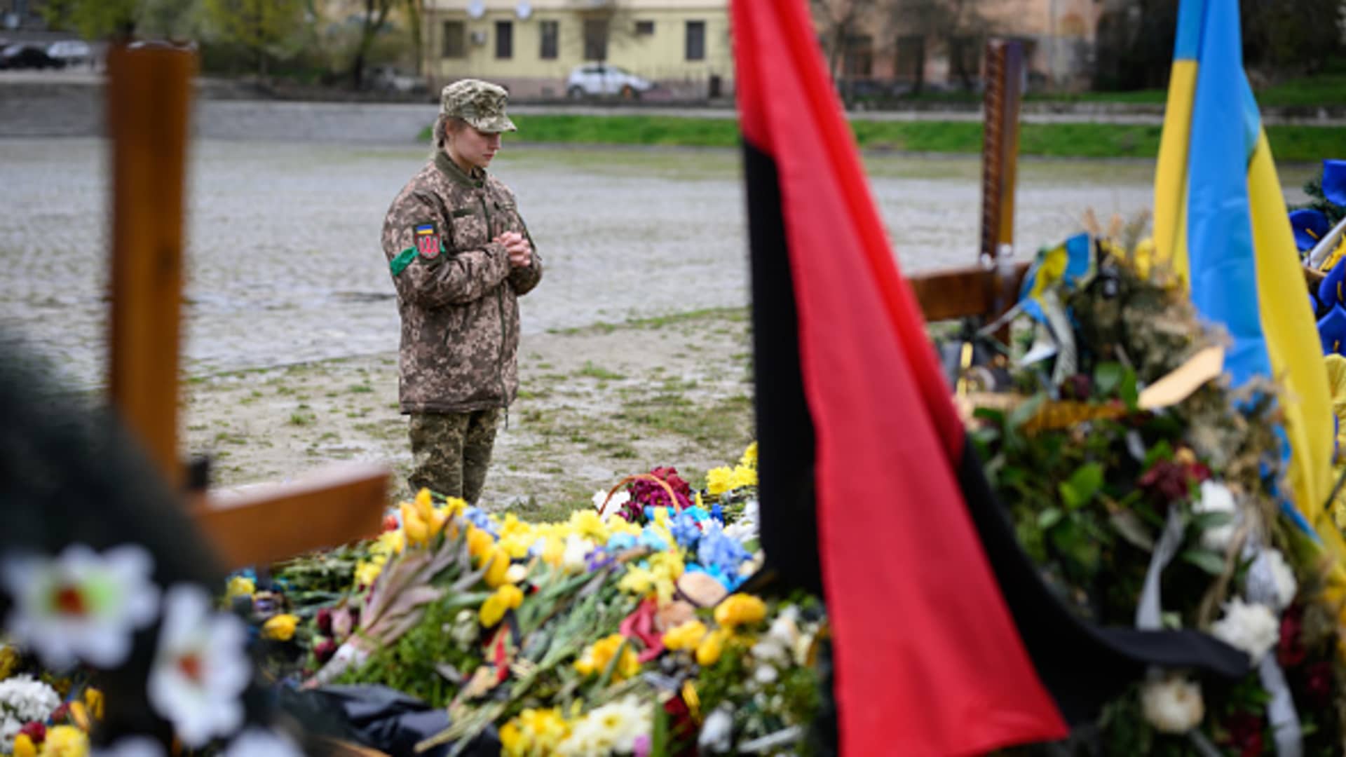 A woman pays her respects at the grave of a fallen soldier in the Field of Mars at Lychakiv cemetery, on April 26, 2022 in Lviv, Ukraine.