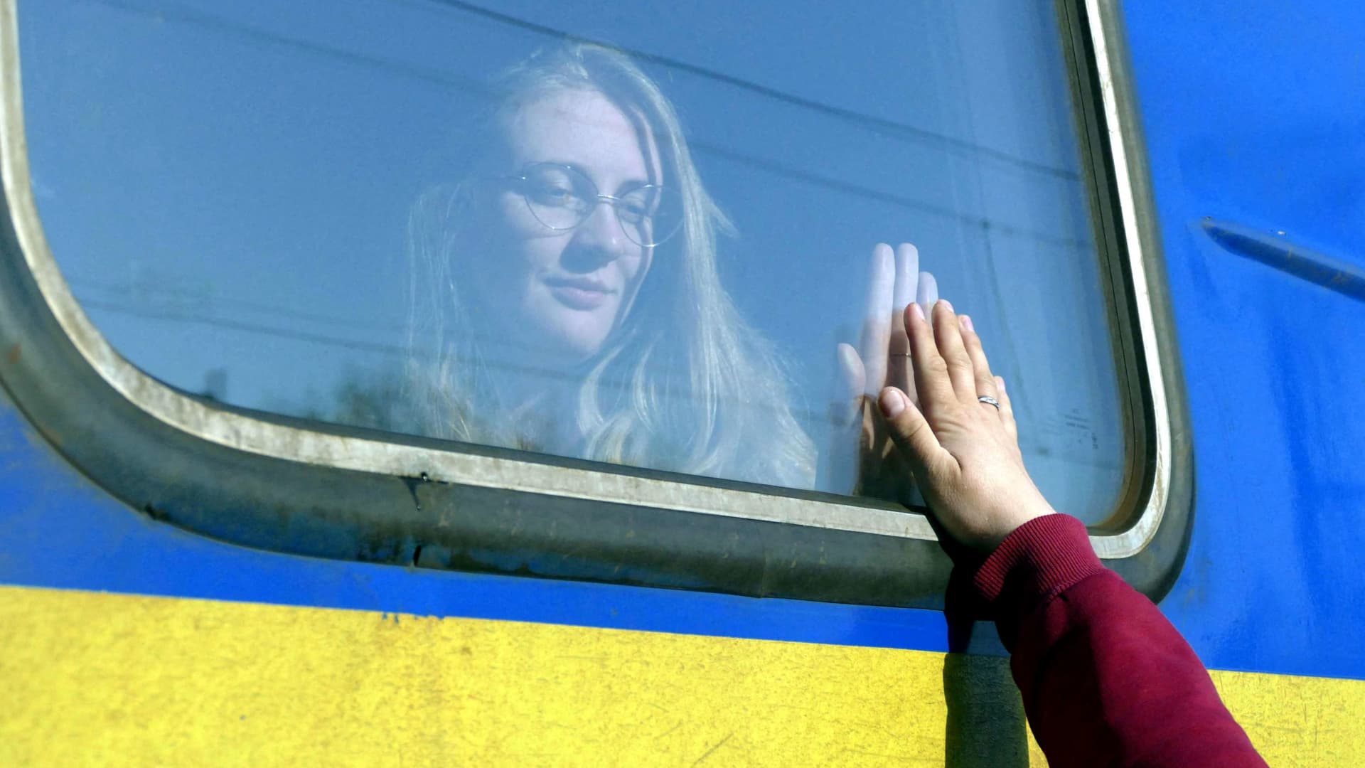 A woman says goodbye to her relative aboard a train travelling to Przemysl, Poland, amid Russia's invasion of Ukraine, in Odesa, Ukraine, April 25, 2022.