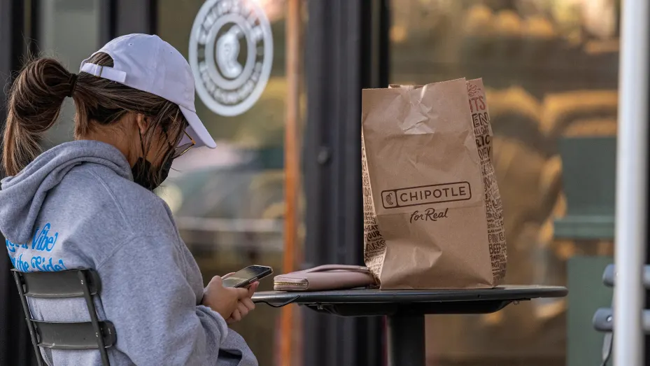 A customer sits outside of a Chipotle restaurant in Santa Clara, California, U.S., on Tuesday, Oct. 19, 2021.
