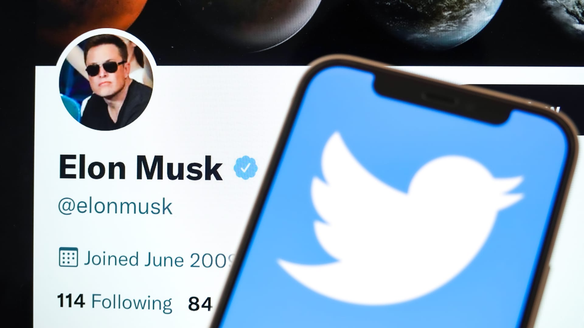 In this photo illustration, the Twitter logo is displayed on the screen of the phone, with Elon Musk's Twitter account in the background. Twitter was flooded with user reports of high-profile accounts losing thousands of followers in the hours after news broke that Tesla CEO Elon Musk would purchase the social network.