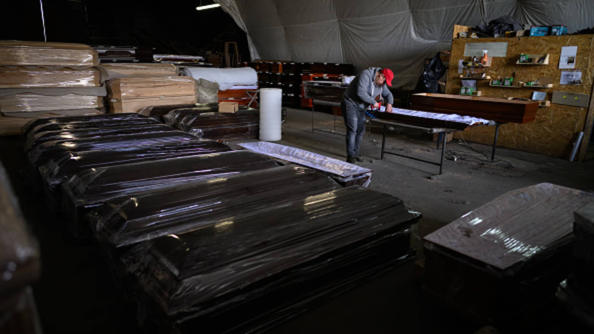 Craftsman Dmytro Hanyuchenko attaches the fabric inserts into a coffin at a coffin workshop on April 28, 2022 in Rava-Ruska, Ukraine.