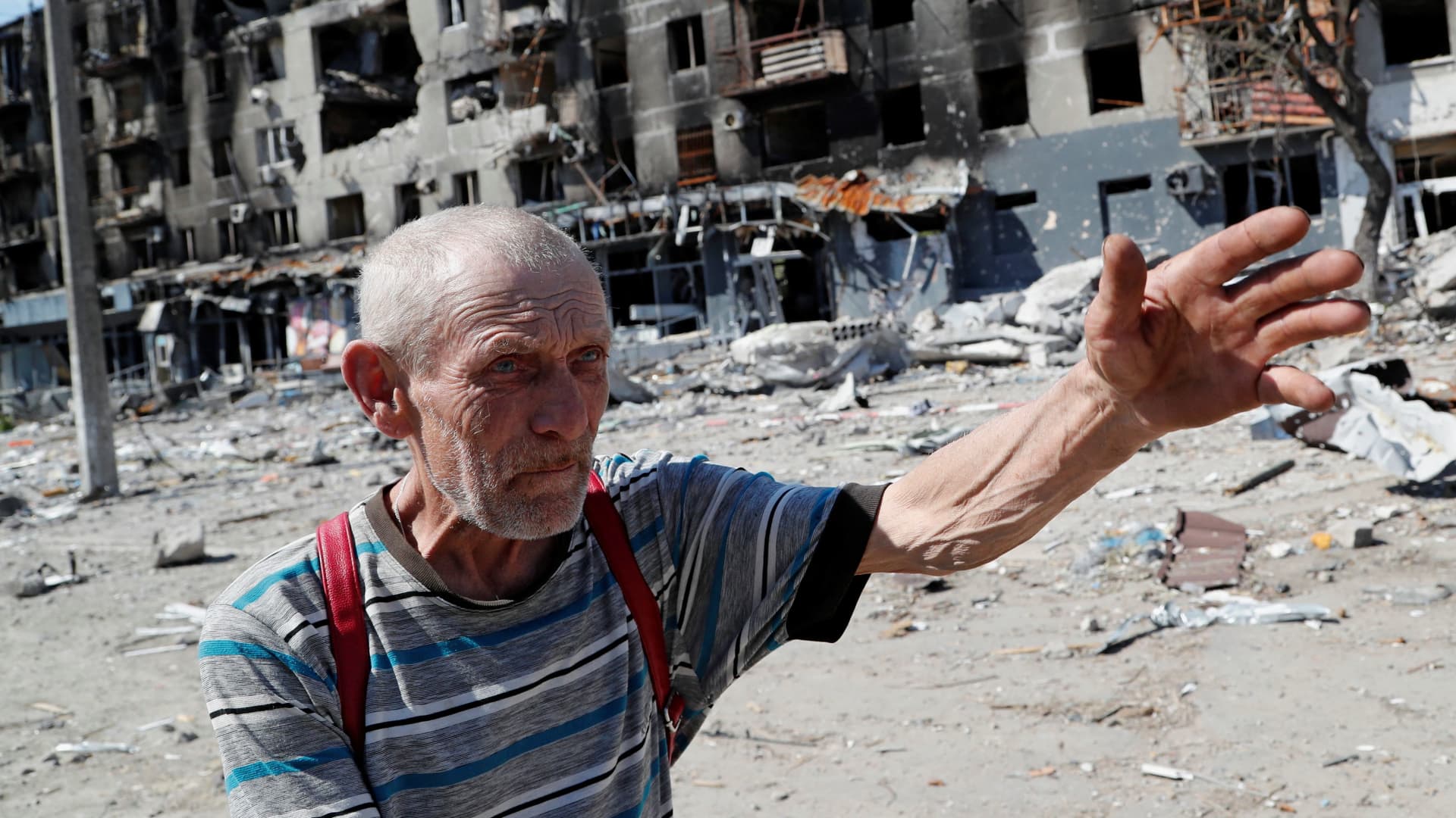 Local resident Vitaly Kudasov, 71, gestures as he speaks near an apartment building destroyed during Ukraine-Russia conflict in the southern port city of Mariupol, Ukraine April 28, 2022.